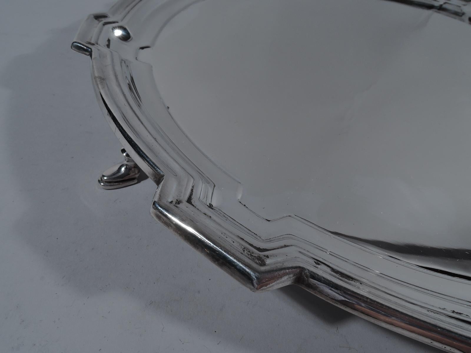 George V sterling silver salver. Made by Roberts & Belk in Sheffield in 1927. Round with molded curvilinear rim. Crisp Art Deco form on three Georgian hoof supports. Fully marked. Weight: 29 troy ounces.