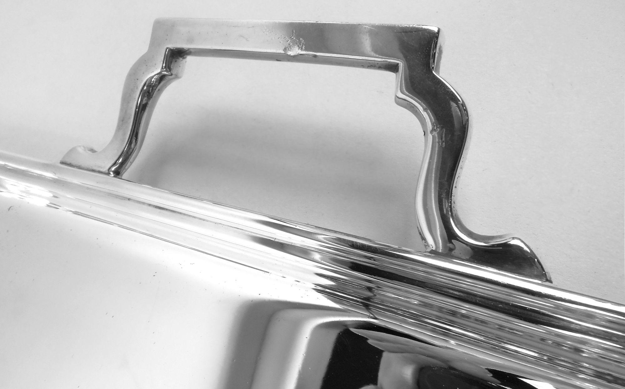 Vassoio da tè in argento sterling Art Deco. Prodotto da Frank Cobb & Co. Ltd a Sheffield nel 1932. Rettangolare con angoli curvilinei e bordo modanato; maniglie a staffa a voluta. Supporti angolari a gradini e rotondi. Completamente marcato. Peso:
