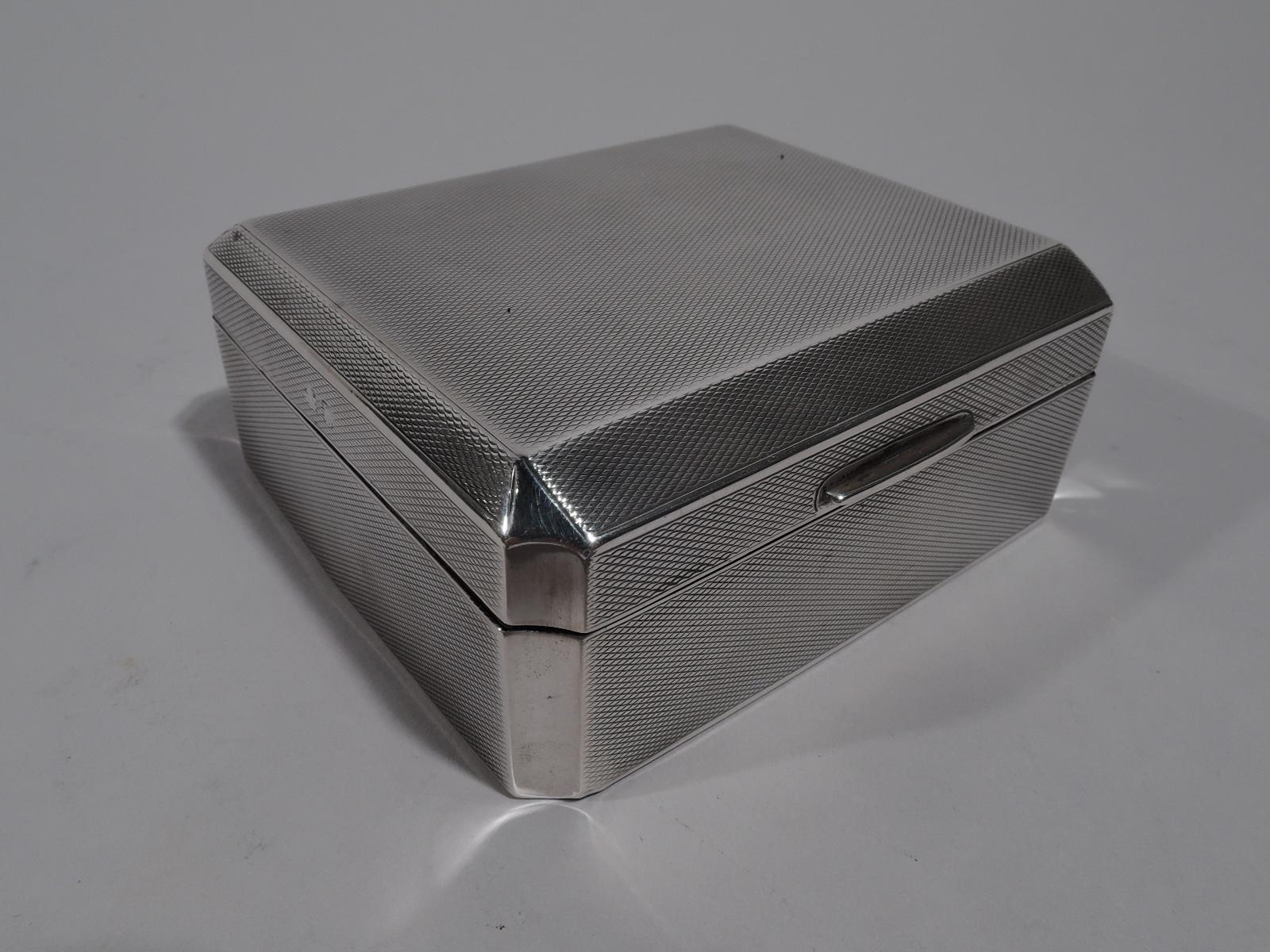 George V sterling silver trinket box. Made by William Neale & Sons in Birmingham in 1928. Rectangular with plain concave corners. Cover hinged and chamfered with linear tab. Engine-turned wave ornament. Box and cover interior cedar lined. Box