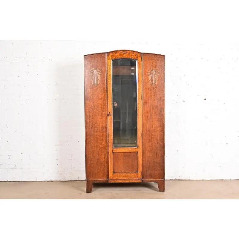 A gorgeous antique English Art Nouveau or Art Deco armoire dresser or wardrobe

England, Circa 1920s

Carved oak, with beveled mirror on door.

Measures: 41.5