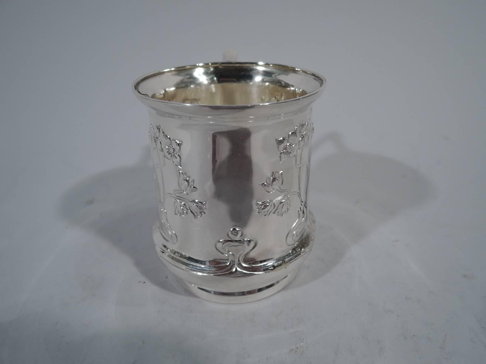 Art Nouveau sterling silver baby cup. Made by George R. Unite in Birmingham in 1905. Discreet baluster with flared rim, reeded and scrolled bracket handle, and short foot. Interlacing and whiplash flowers and tendrils forming two frames (vacant). An