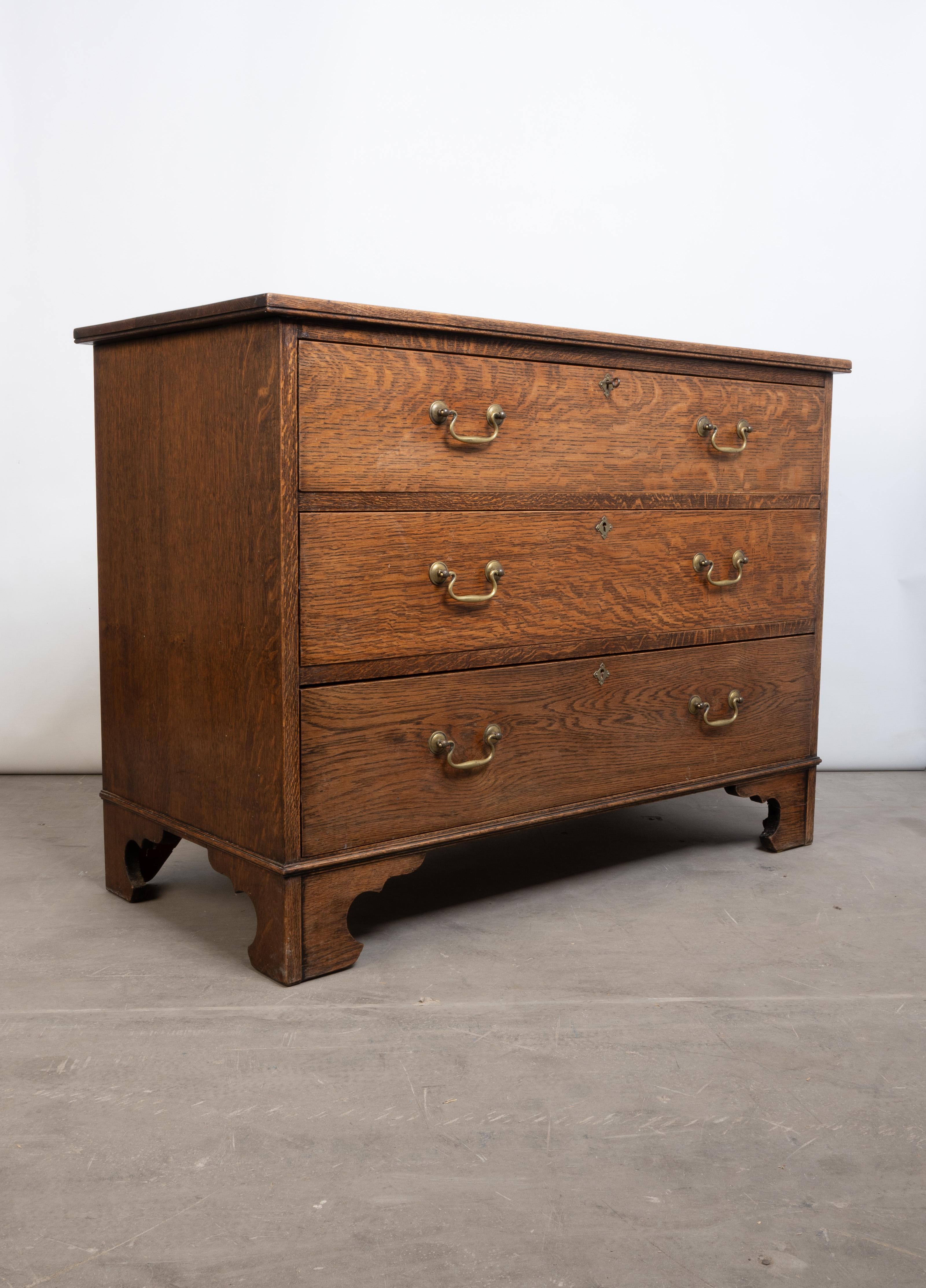 Antico cassettone inglese Arts And Crafts in Oak dorato C.C.
Di proporzioni da comodino. Tre cassetti lunghi, che conservano i fermi in ottone originali e la chiave. In piedi con i piedi a staffa.

In ottime condizioni commisurate all'età. Una