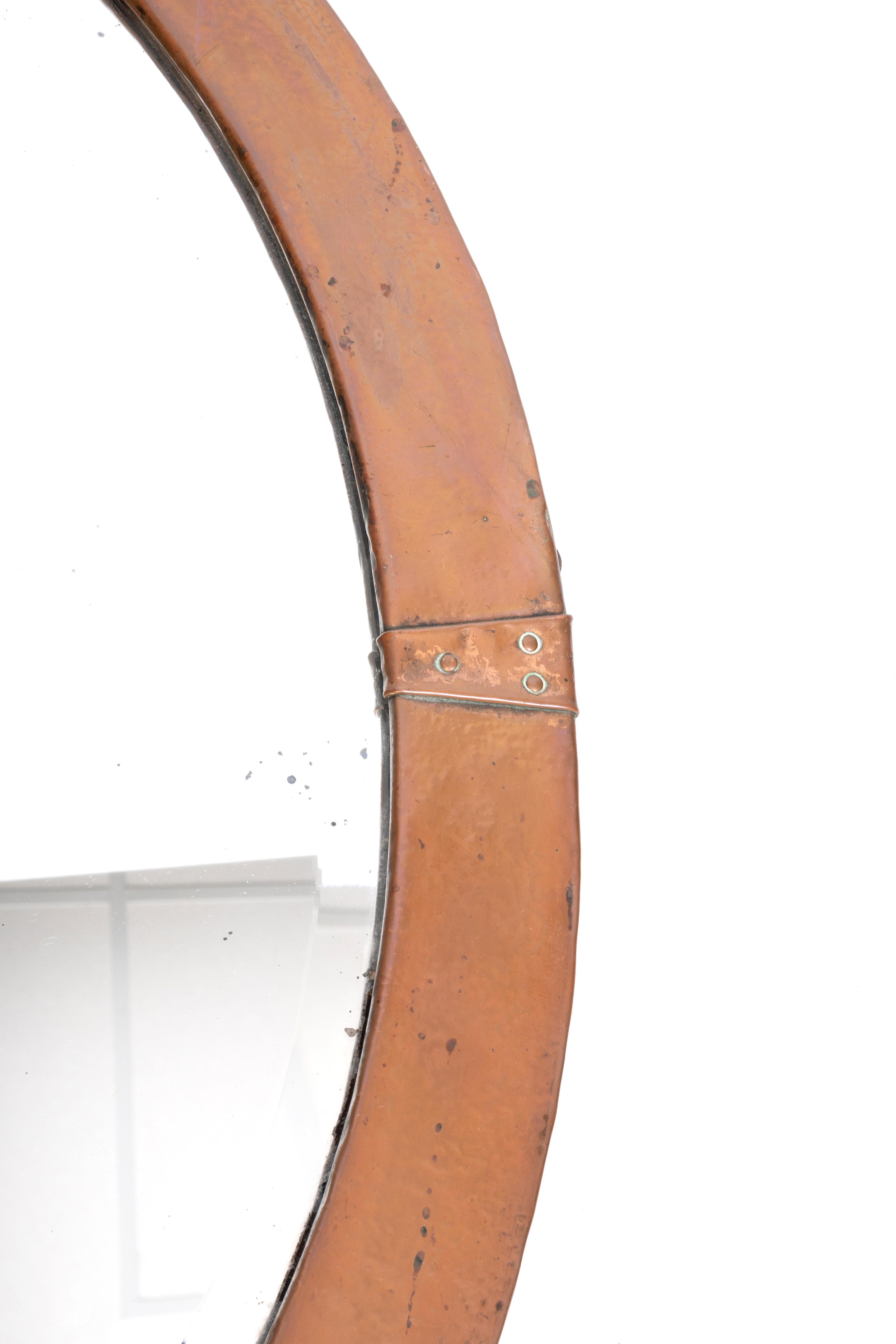 Antique English Arts And Crafts Oval Copper Mirror C.1900

An Arts and Crafts hand hammered copper oval mirror with riveted straps and its original bevelled mirror. 
Patination to the copper, in good condition commensurate with age.

57cm x 42cm
