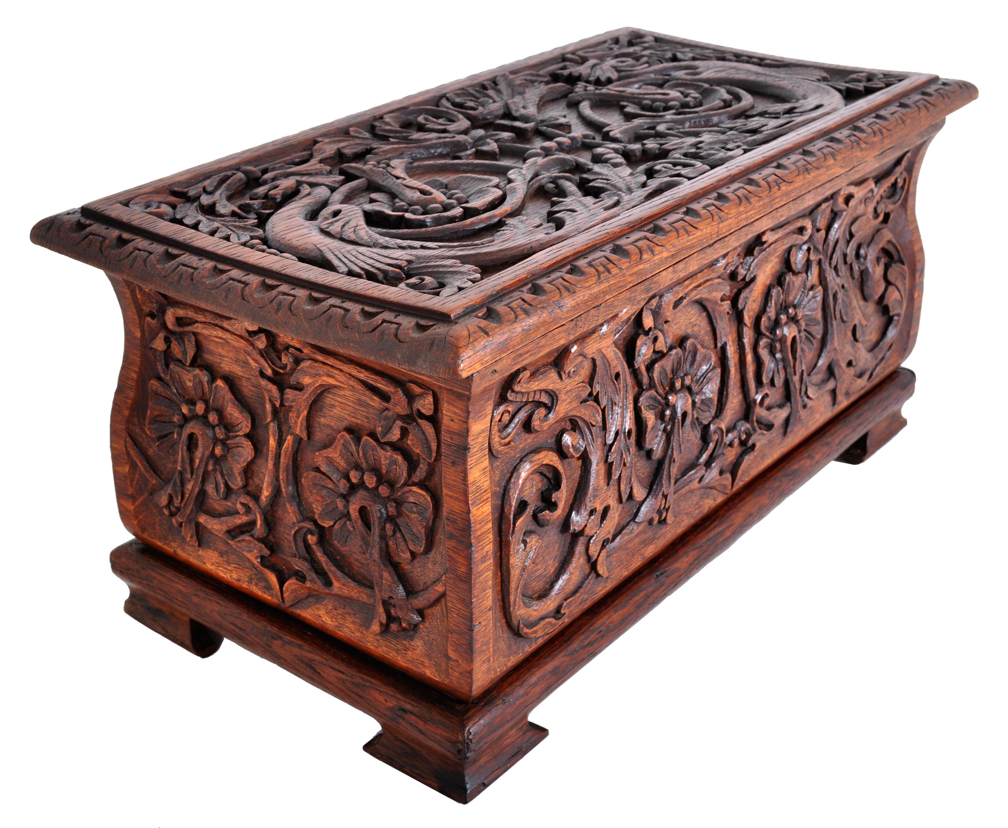 A good antique Arts & Crafts carved oak coffer, box, circa 1900. The coffer of ogee shape and having a hinged lid. The box is finely and deeply carved with dragons nestled within a floral design.