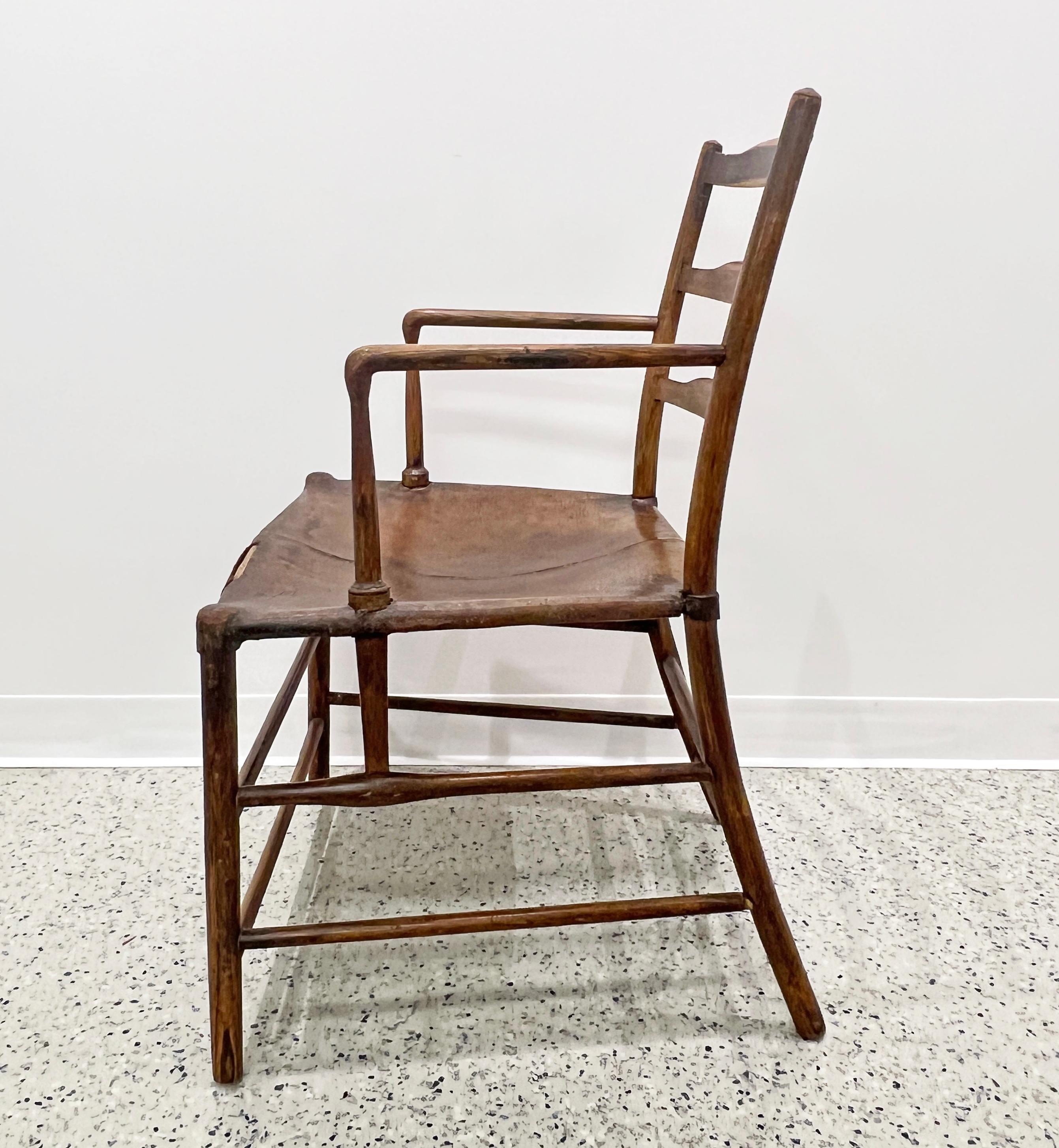 English antique armchair made by the Guild of Handicraft of Charles Robert Ashbee, a designer and architect and central figure of the English Arts & Crafts Movement. Elegantly carved in solid ash woods with superb original color. Features a raked