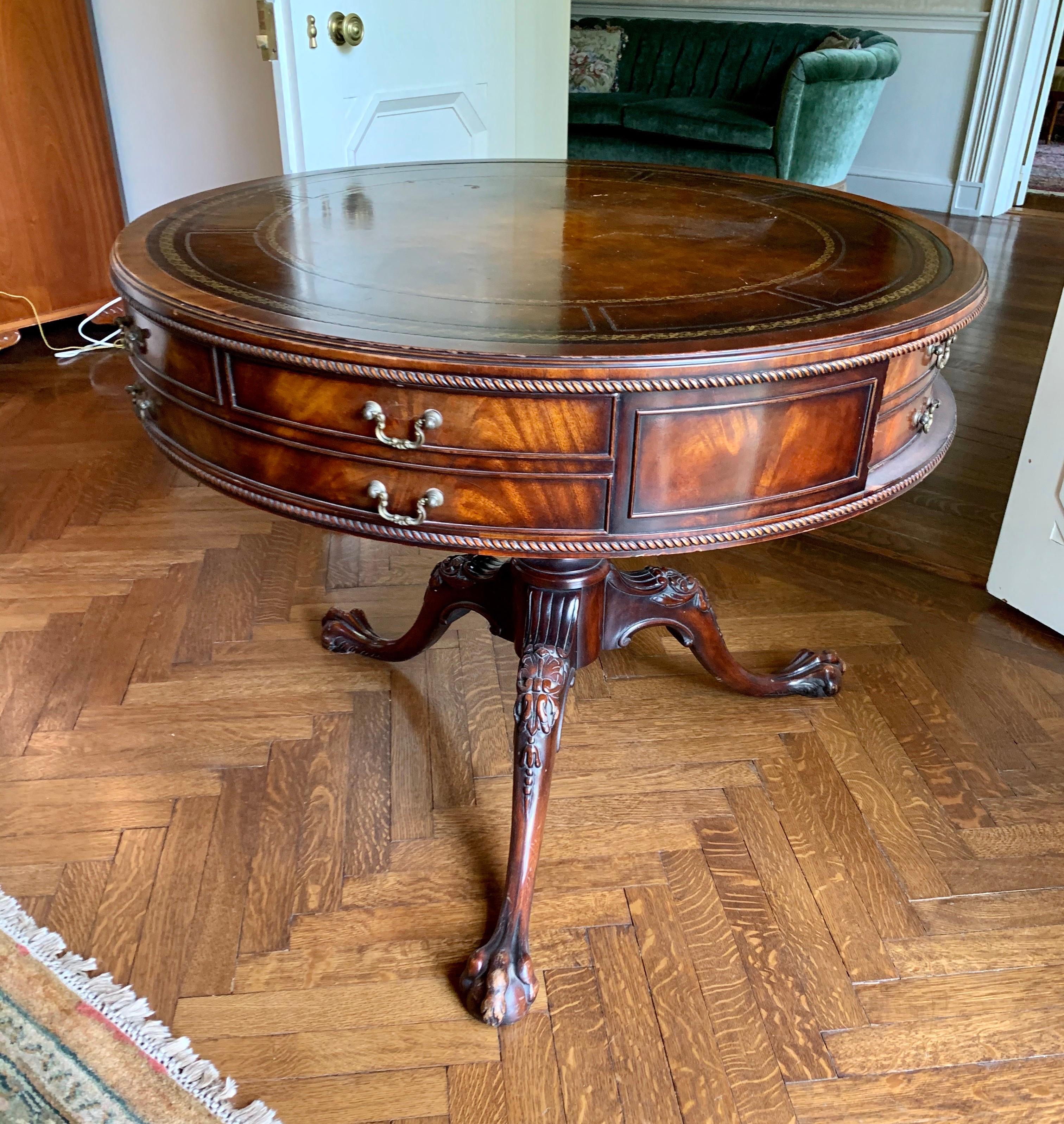 English drum table with gorgeous mahogany throughout and a leather top, circa 1920s
Features one real drawer and the balance, faux drawers. Great lines and better scale.
The ball and claw feet and formidable and really set this piece apart. Very