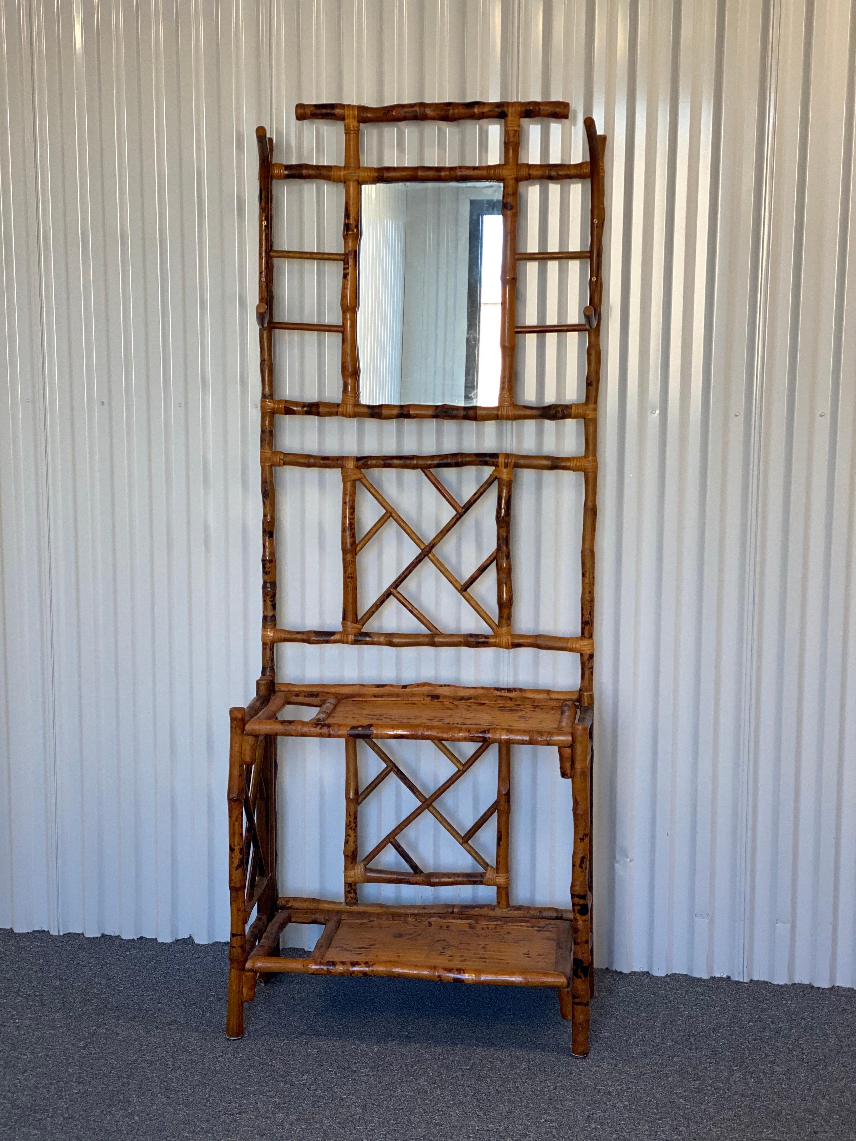 Antique English bamboo coat rack hall stand
A bamboo stand with Chinese Chippendale style design including two shelves, a slot for umbrellas on the left, and two curved hooks between a mirror. This is a lovely piece in overall very good condition.