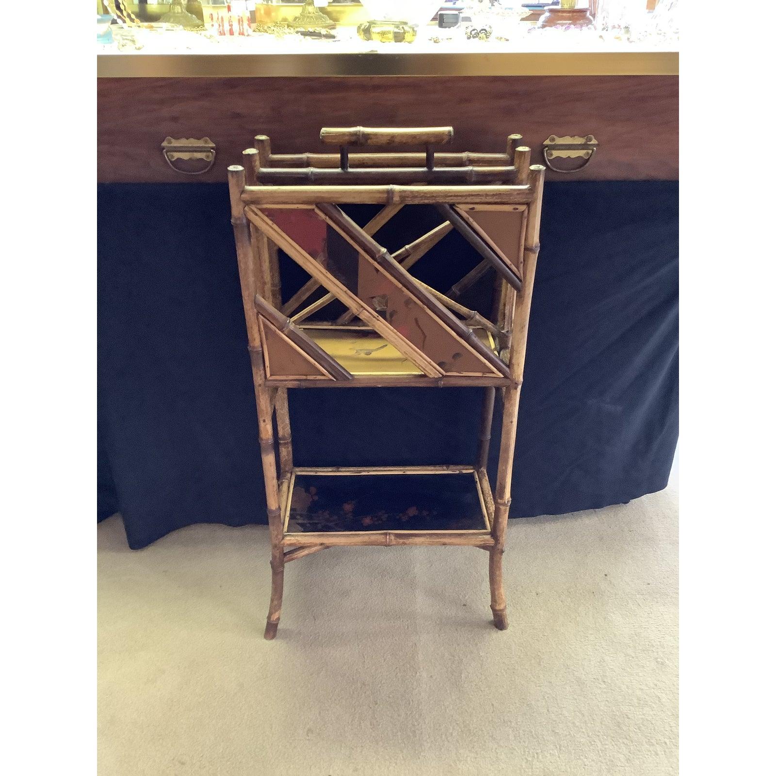 English bamboo Anglo-Japanese magazine rack with two wide slots for magazines, chinoiserie lacquered panels and a large shelf on the bottom. This English magazine holder has beautiful brass fittings.




