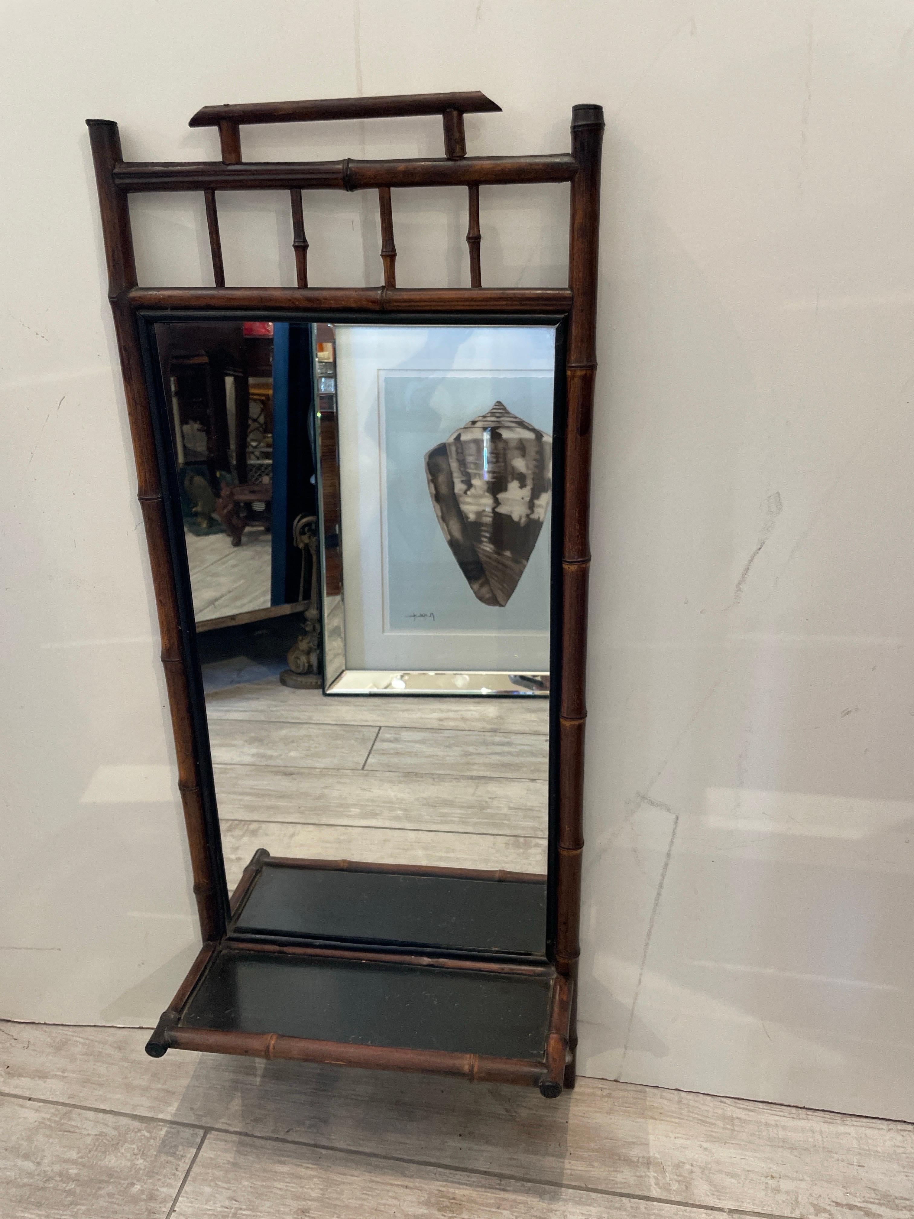 Unique antique English bamboo wall mirror with shelf at bottom. Mirror plate size is 12 by 22. In the Chinoiserie Pagoda form.