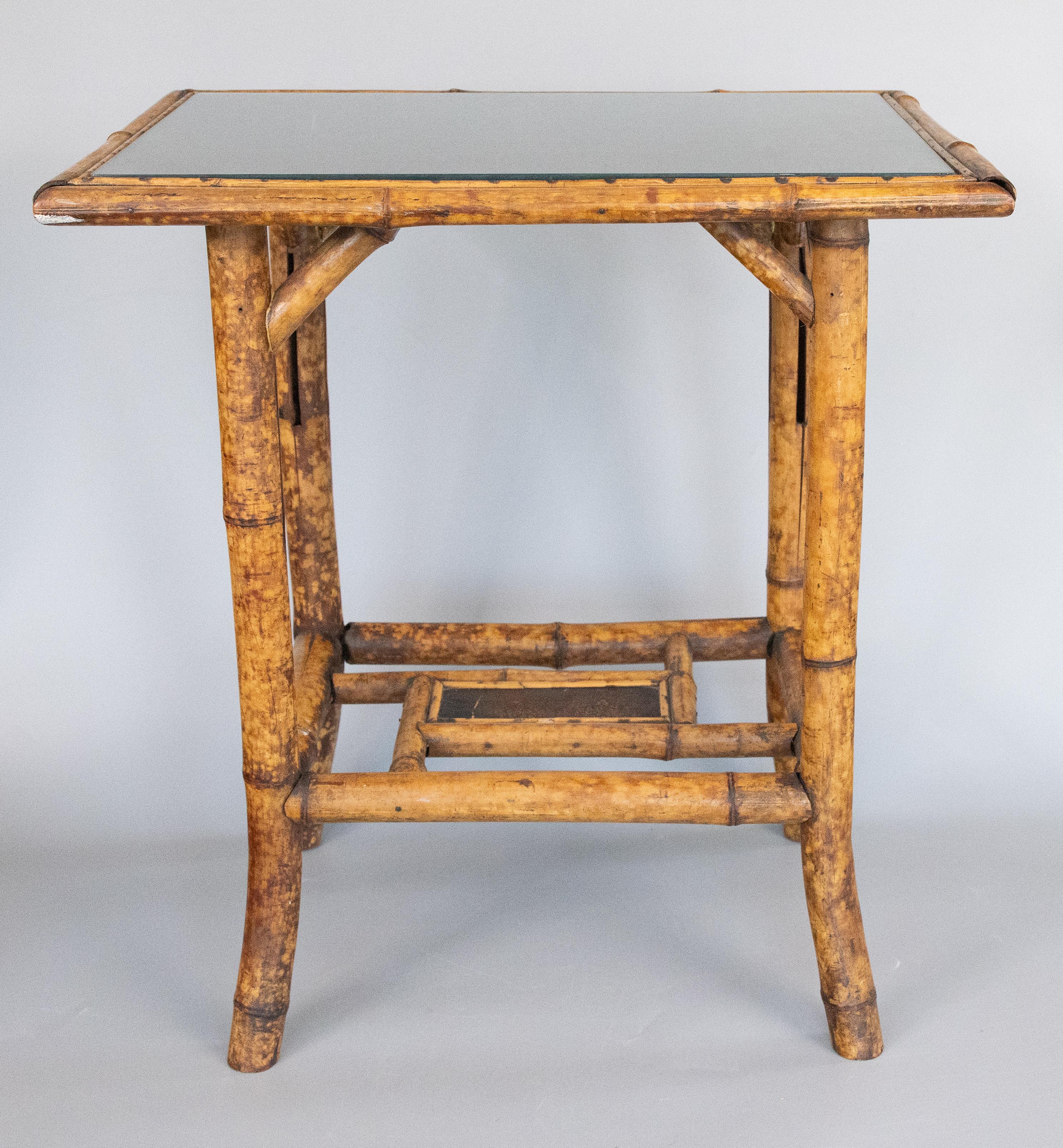 A superb antique English Arts & Crafts period bamboo rectangular two tier side table, circa 1900. This fine table has a removable custom glass insert for the the table top, the old embossed leather top and lower shelf, and beautiful tortoise bamboo