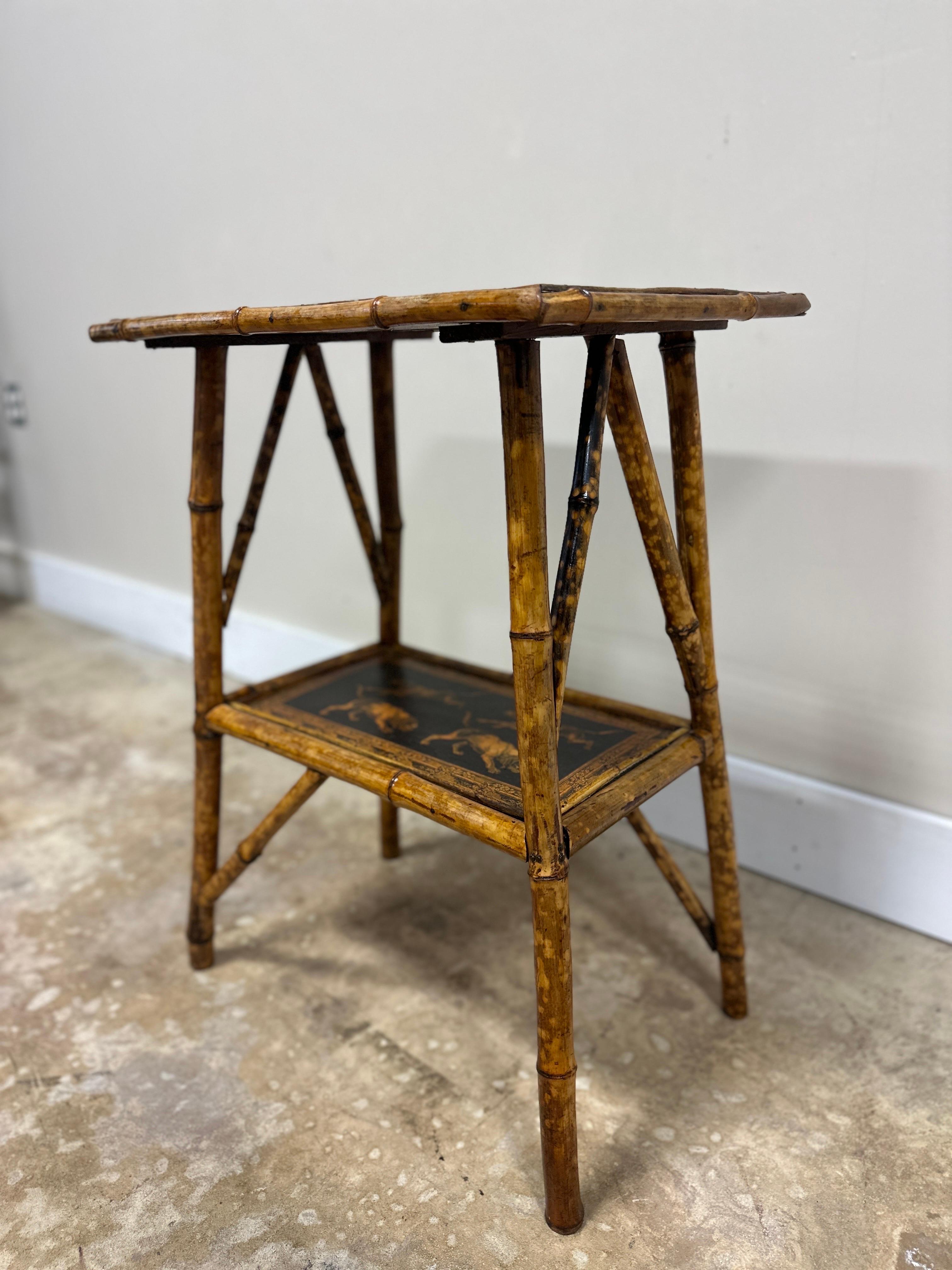 This antique English bamboo side table effortlessly blends classic craftsmanship with a touch of contemporary artistry. Its new artisan decoupage showcases a whimsical yet refined dog motif. The artwork is carefully applied by hand, bringing a