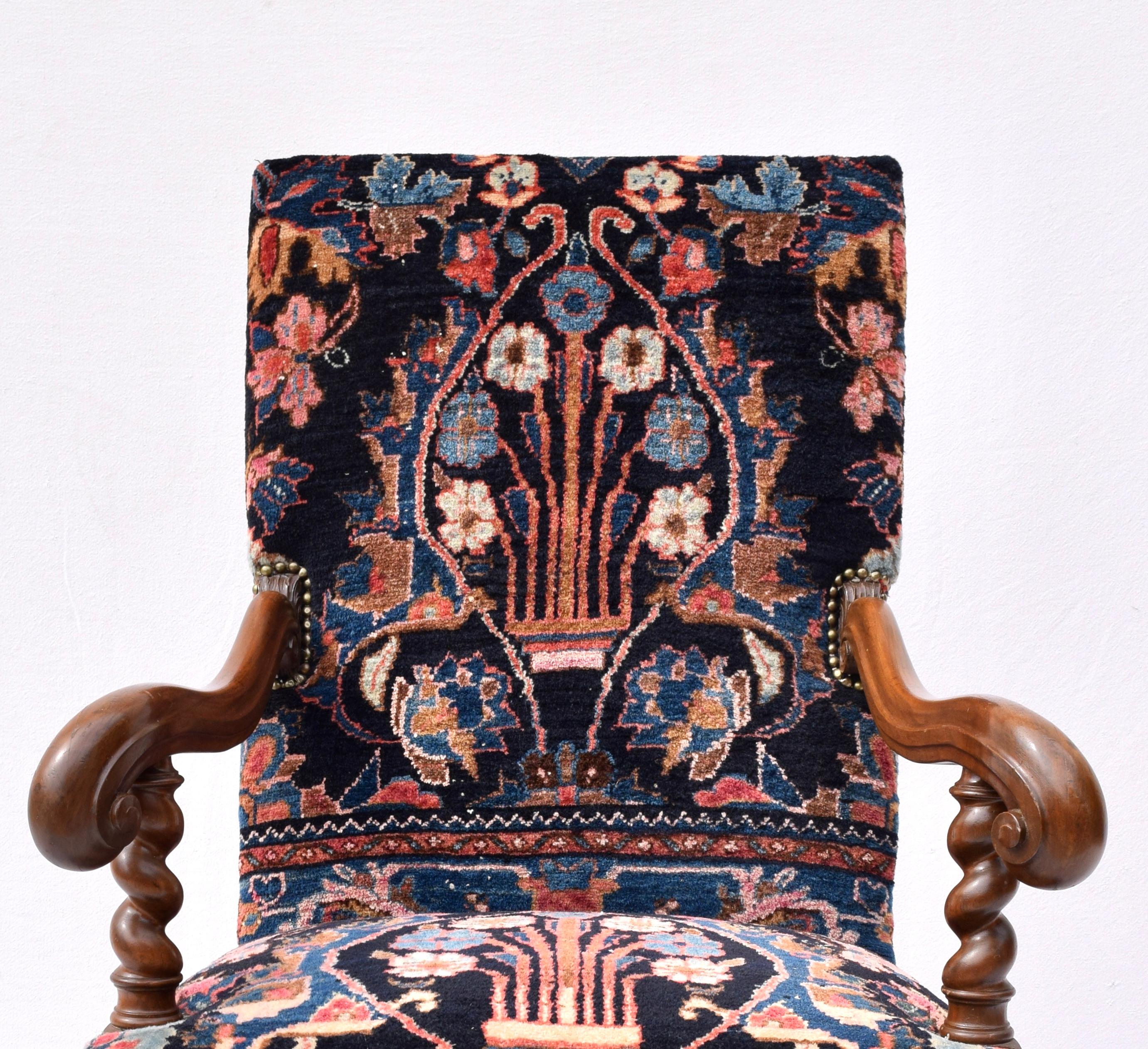 Fully restored one of a kind antique English armchair in its antique oriental carpet upholstery having splayed scroll carved arms with barley twist arm, leg and front stretcher. Solid walnut construction. Measures: Seat height 20