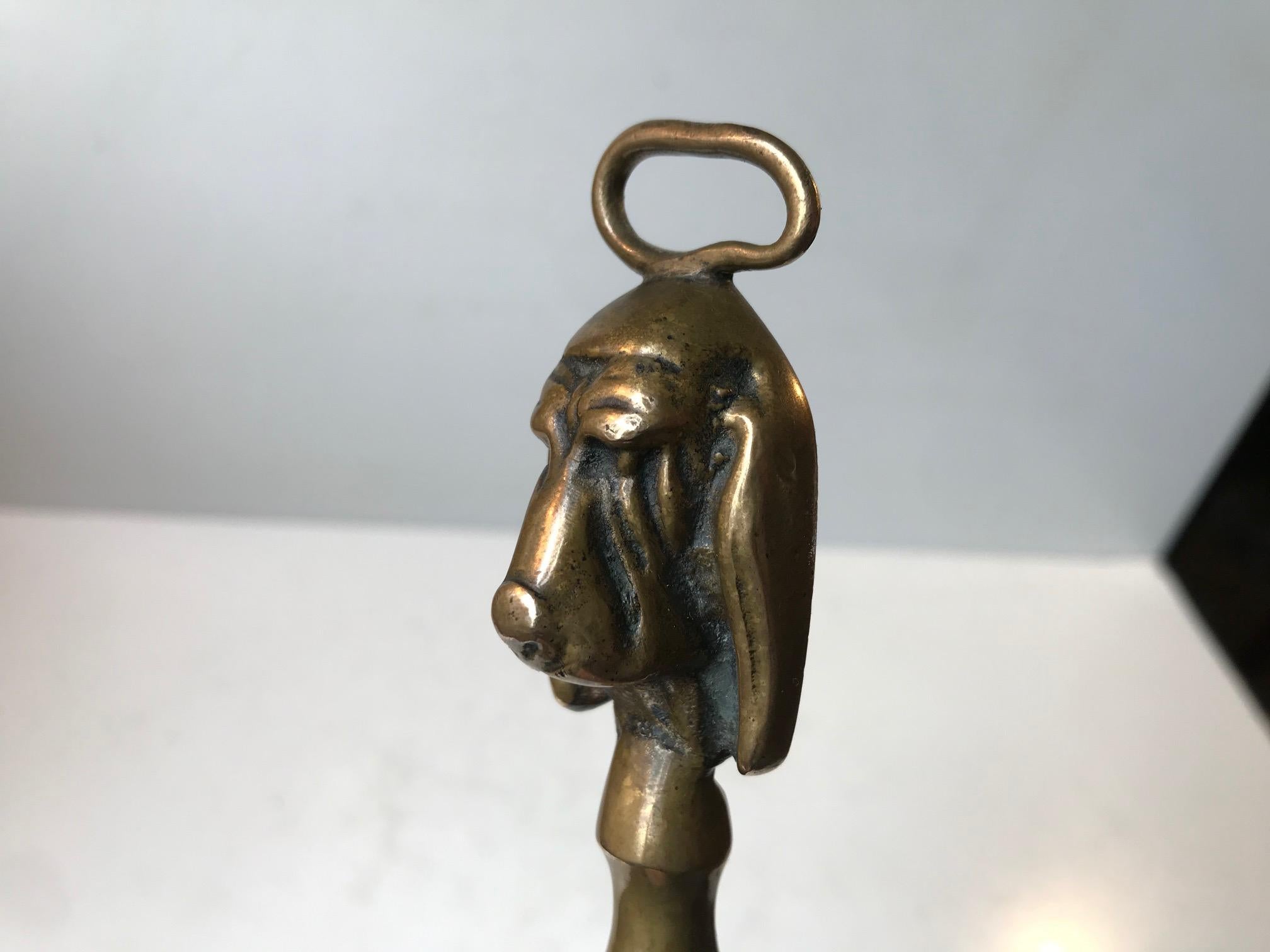 Elegant long shoe horn in patinated brass set with the head/face of a Bassett hound in bronze at the top. It can be wall hung in your entrance. The horn itself is intensionally bend to fit better around the backside of your heel. It was handmade in
