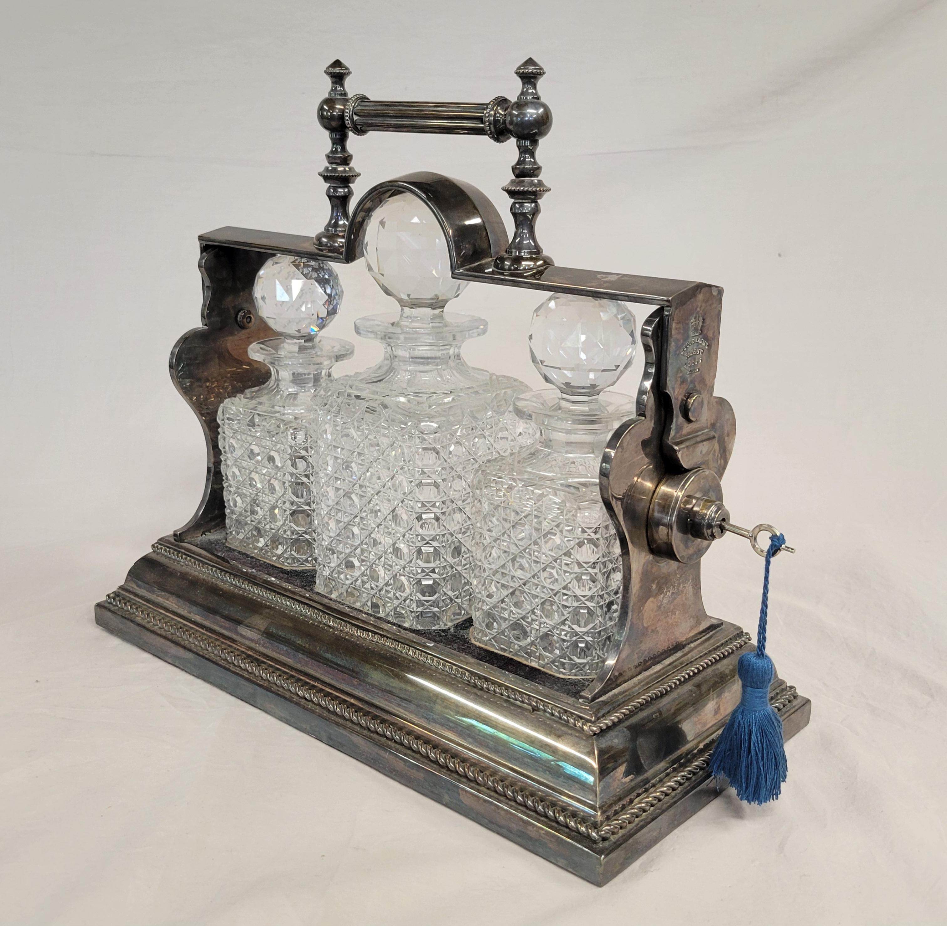 Un superbe tantale en argent anglais de la fin des années 1800 ou du début des années 1900, à trois bouteilles, fabriqué par Betuemann's, Londres, en bon état de fonctionnement. Les trois flacons en cristal semblent être d'origine car ils sont