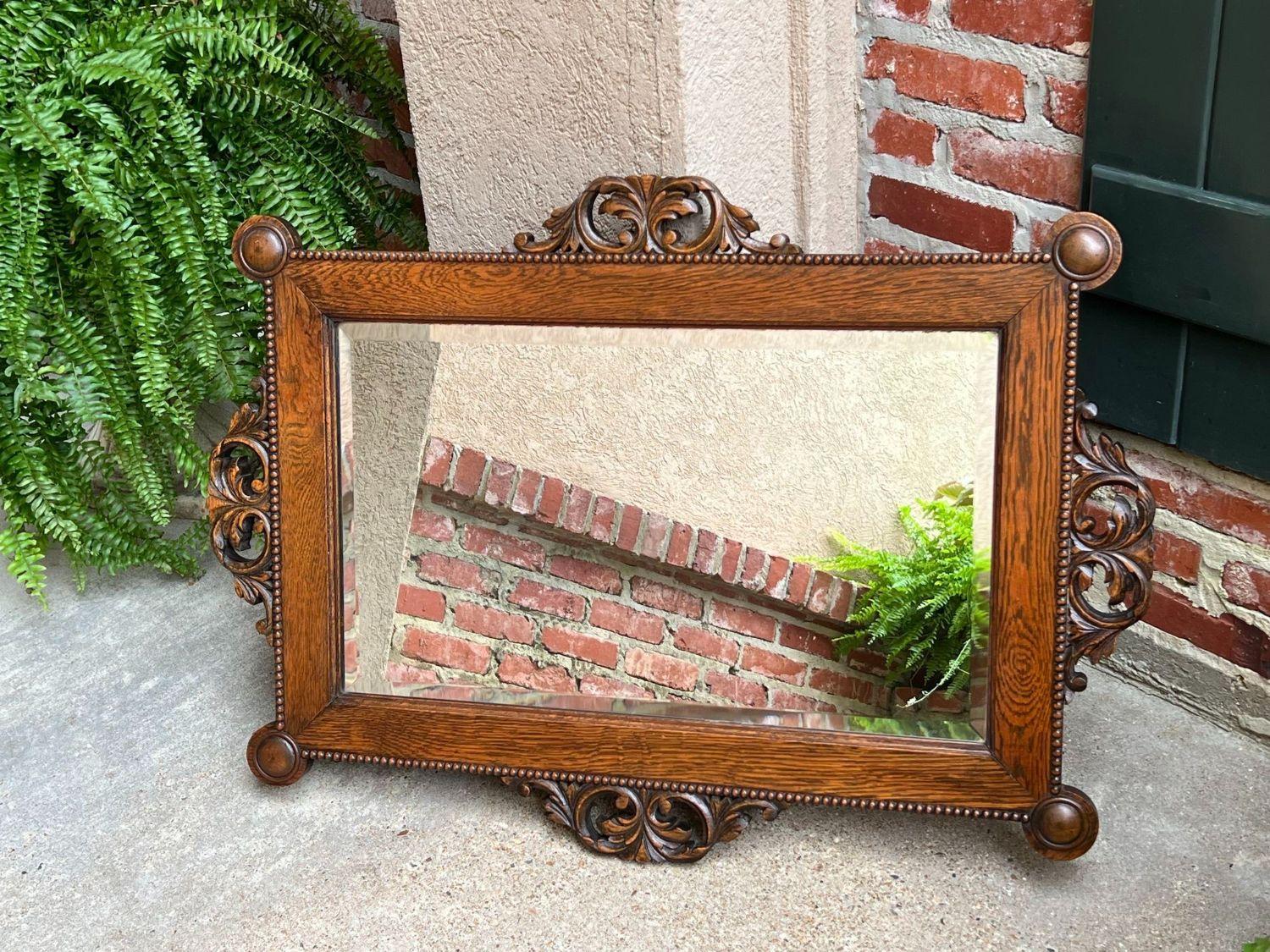 Antique English Beveled Wall Mirror Carved Oak Frame Jacobean Arts & Crafts.

Direct from England, another fabulous antique English wall mirror!
The large rectangular frame features a wide, tiger oak band with beaded trim on the outer edges, ornate
