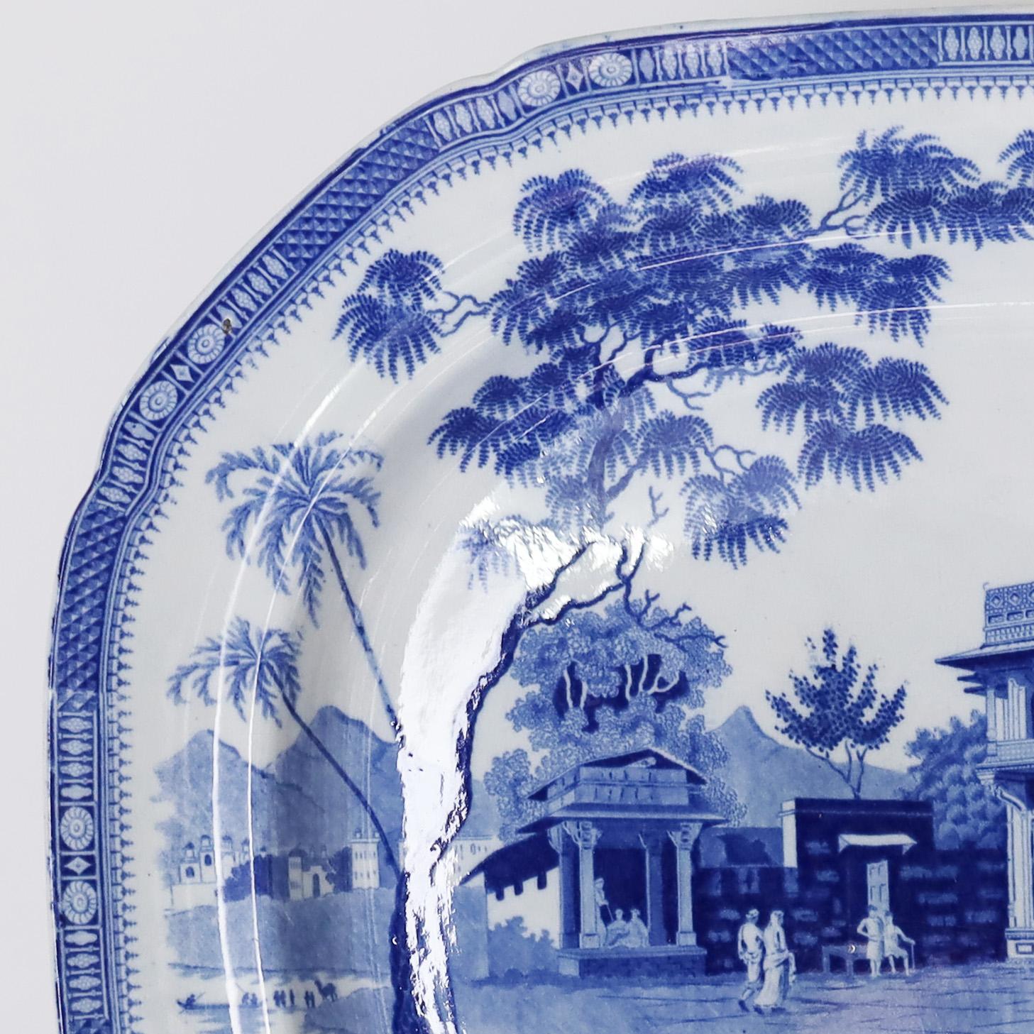 Fino plato de cerámica orientalista inglesa en azul y blanco del siglo XIX, obra de John Rogers & Sons, Staffordshire, que representa un paisaje chinoiserie bordeado de árboles y con un camello en servicio. Con el sello Rogers 20 en el reverso. Como