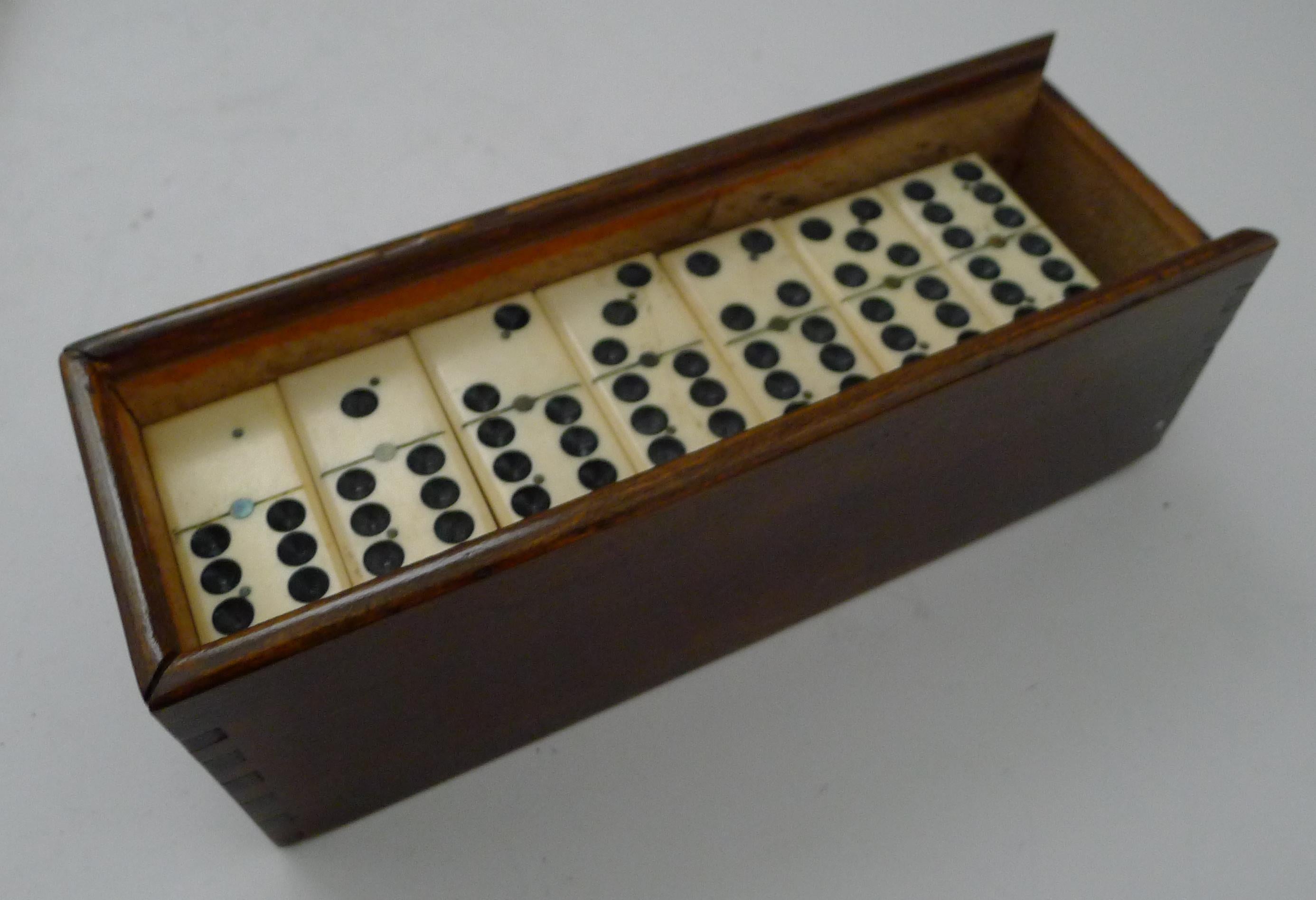 A charming set of late Victorian dominoes or dominos, complete with a handsome polished wooden storage box with a sliding lid.

Dating to around 1900, the set is better than many, with a quality finish, each Domino with rounded edges, the bone and