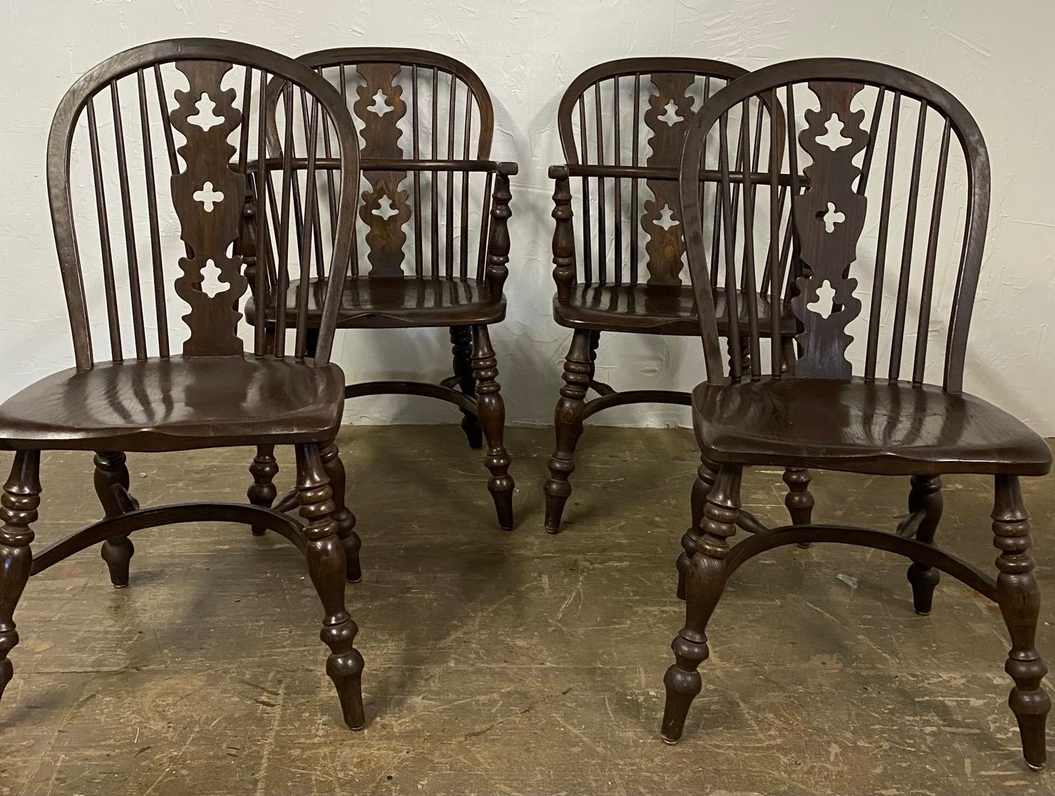 Four English Windsor bow-brace spindle back dining chairs with decorative splat and finely turned legs and stretcher consisting of 2 host and hostess chairs and 2 side chairs. All four chairs are structurally very sound with one chair seat showing