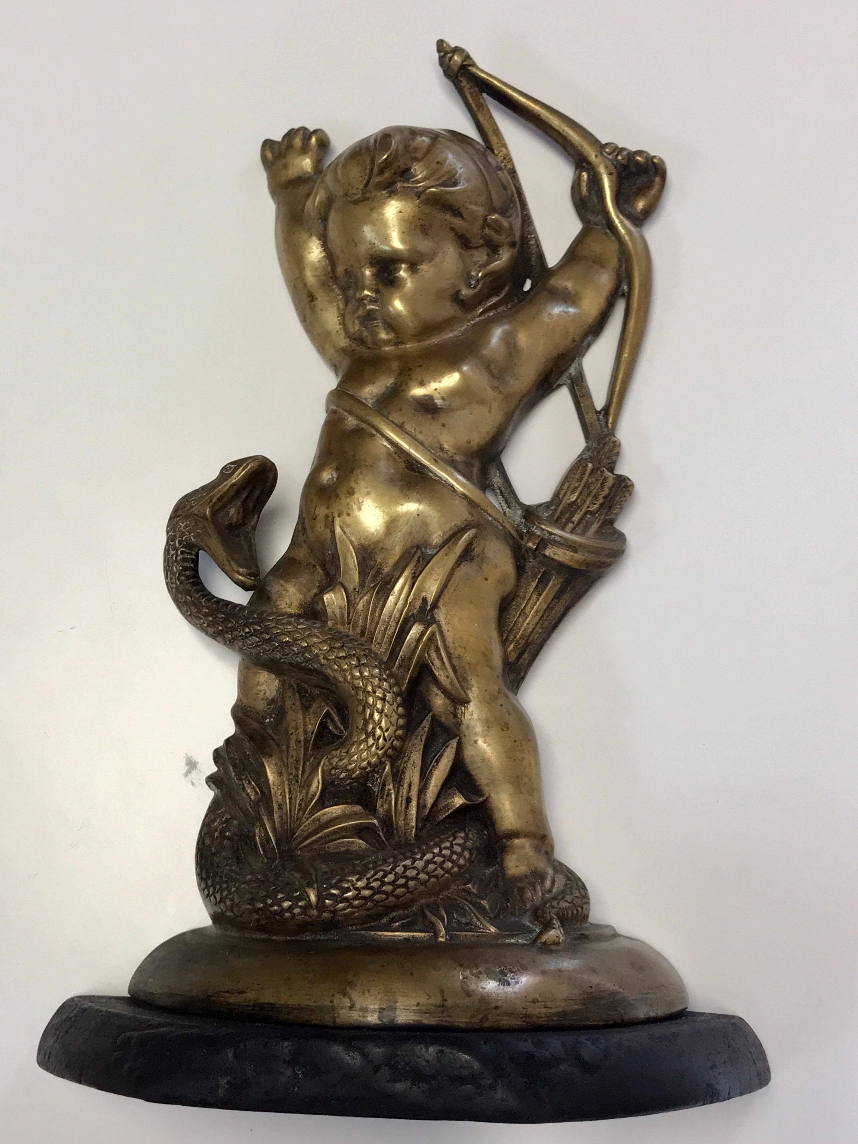 Antique English brass and iron cupid with serpent doorstop, finely cast, stamped: Rd No 530354 on back, raised on a cast iron demilune base.