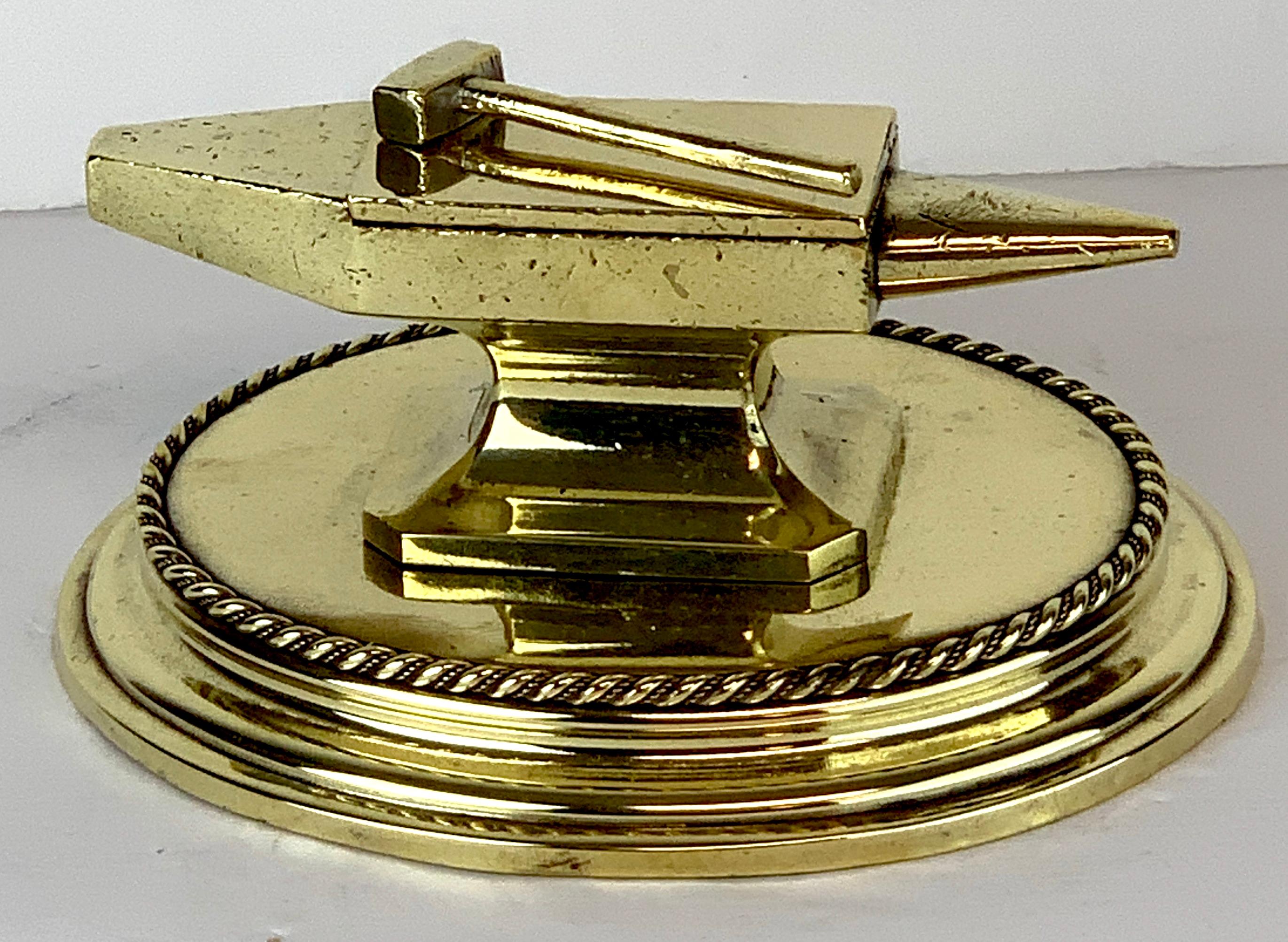 Antique English Brass Anvil Matchstrike, Realistically cast and modeled, as an anvil, with lift top revealing the match caddy and strike on the lid, resting on a rope edge oval base. Professionally polished, ready to place.