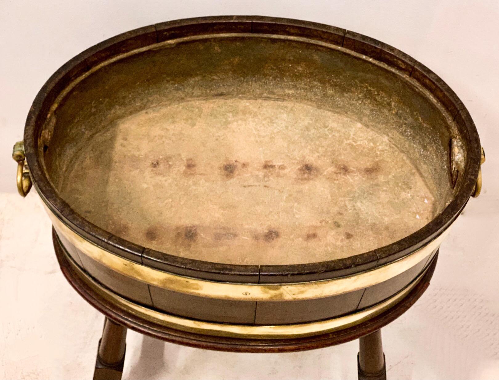 This is a wonderful antique English brass bound cellarette. It is hand hewn peg construction. It has the original zinc liner. The bucket portion is removable from the base. The base has turned legs. Overall, it is in very good antique condition.