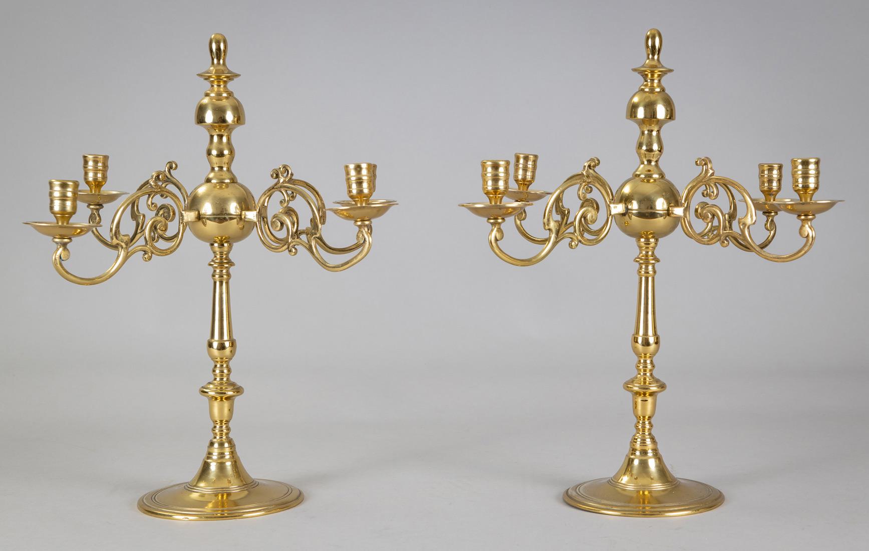 Pair of English solid cast brass four-arm candelabras on a circular base, the arms emanating from the ball on the turned central shaft, the arms are decorated with spurs, the candle cups have ring turnings and the bobéches are deep. Not electrified.