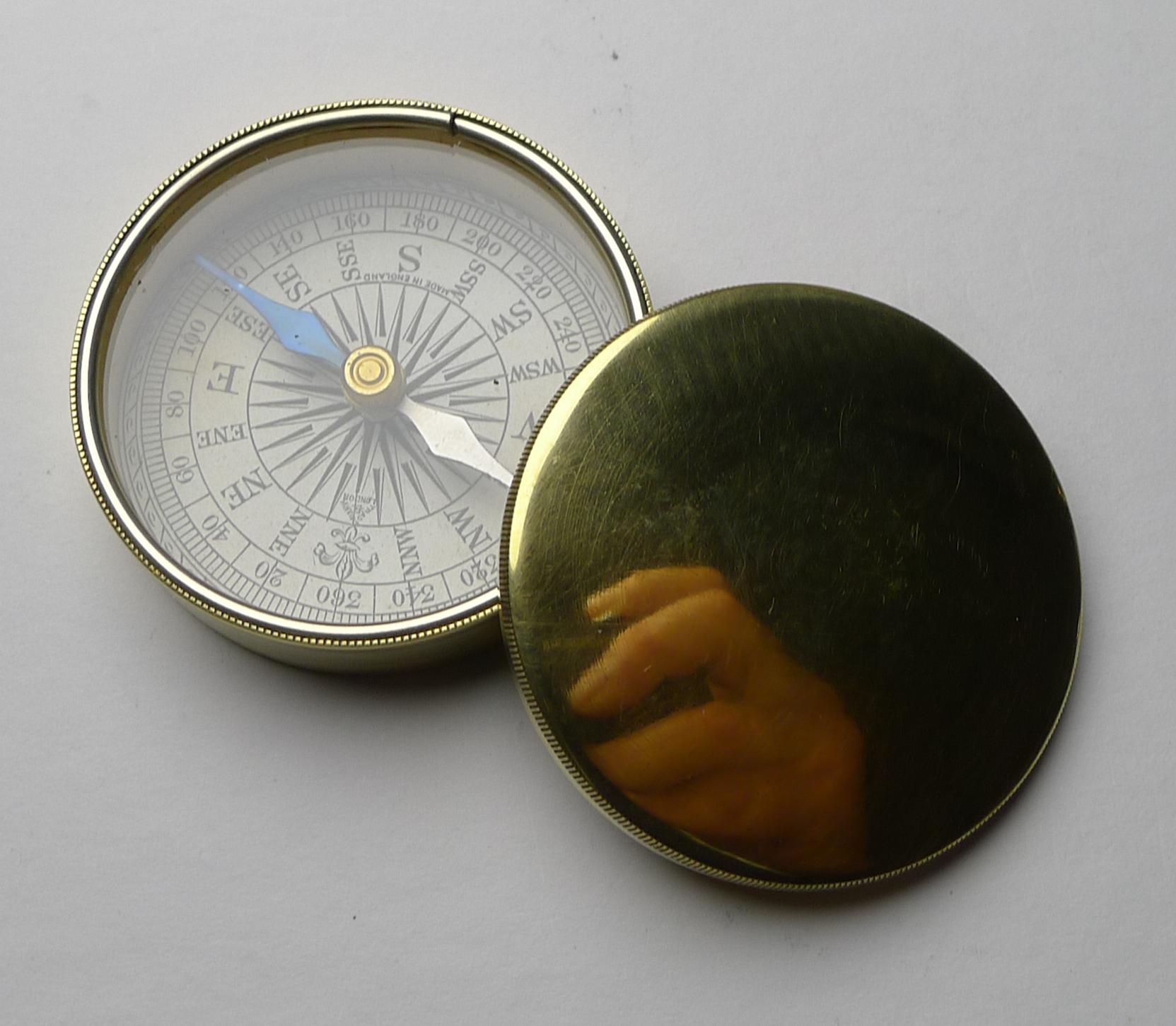 Un élégant compas de voyage en laiton du début du vingtième siècle avec un couvercle pour protéger le verre. 

Le cadran de la boussole est en papier imprimé et comporte les mentions 