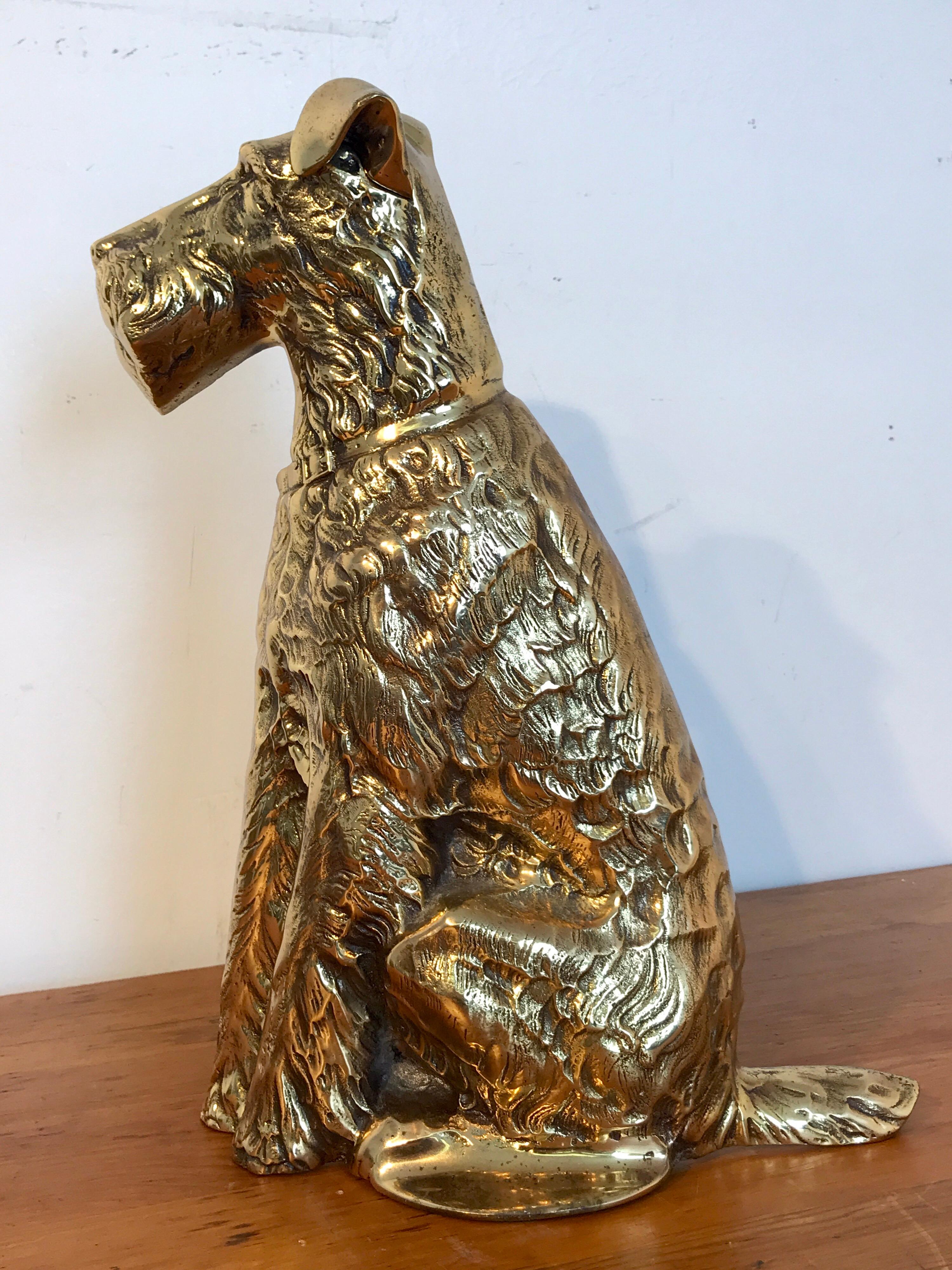 Antique English brass doorstop of a seated terrier, realistically cast and modeled.