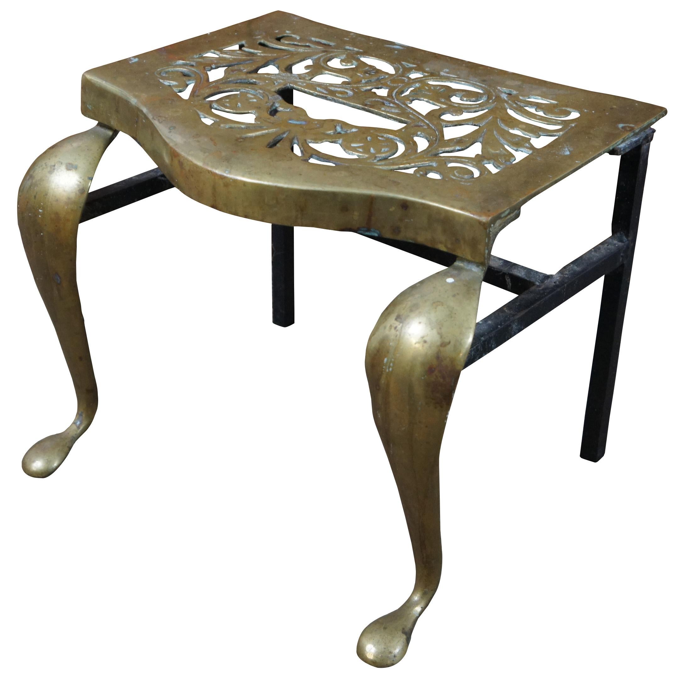 An exceptional and rare early 19th century brass and cast iron fireplace trivet or footman stool. Made by Old World FDRY Guild in 1809. Great for use as a bench or stand. Features cabriole front legs and pierced / reticulated leaf pattern design