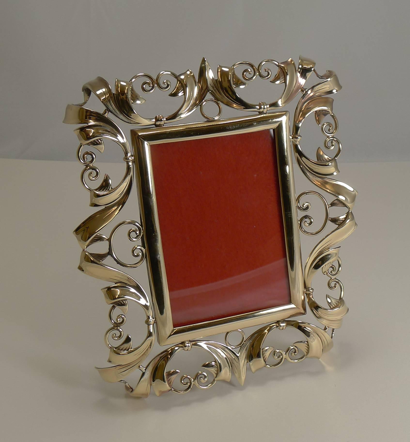 A beautiful and highly decorative photograph frame made from beautifully worked English brass having been professionally polished to gleam.

The back reveals the original folding easel back stand. Excellent condition with an overall measurement of