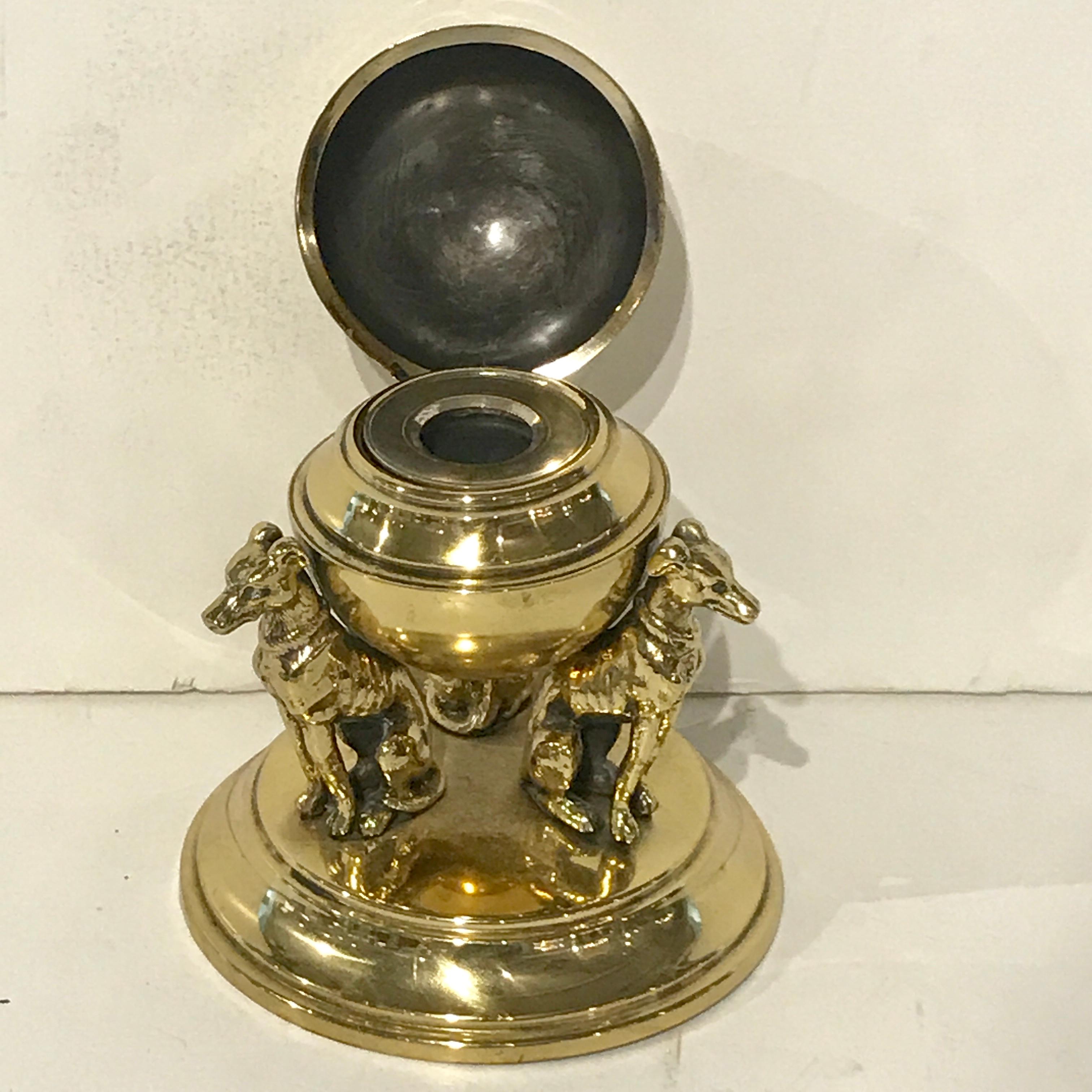 Antique English brass whippet motif inkwell, of circular form with removable brass-mounted inkwell, raised with three seated whippets.