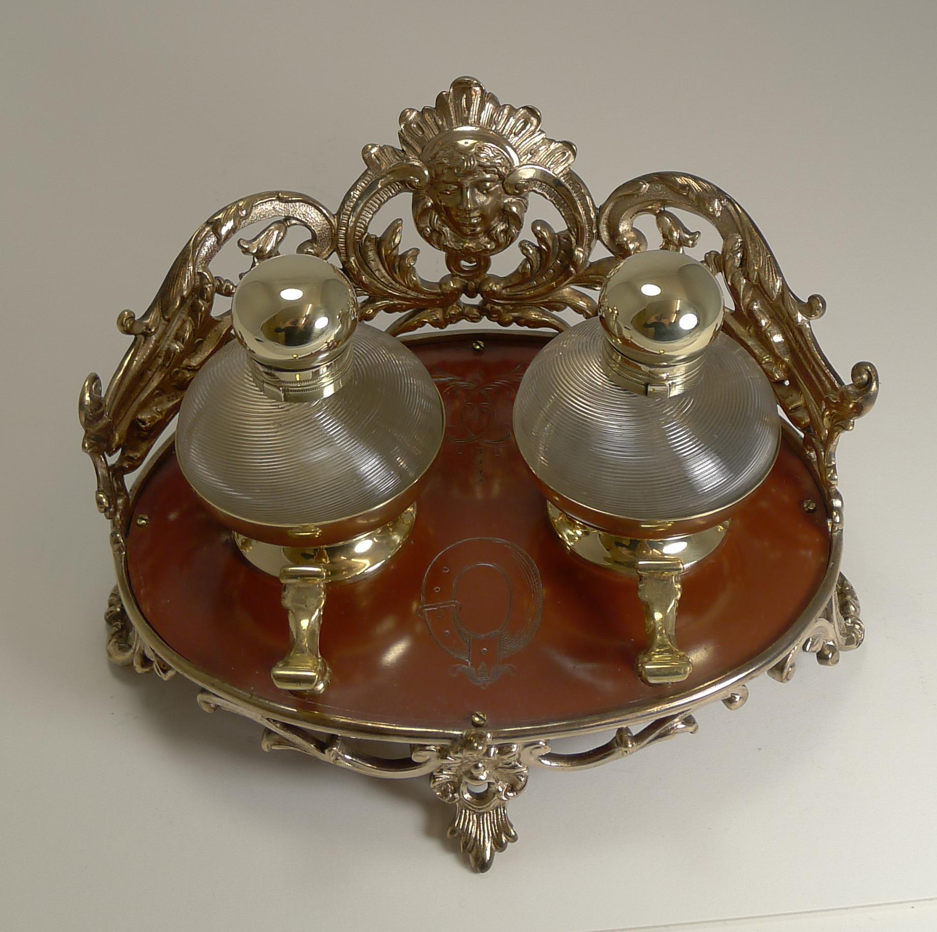 A truly unusual and quite spectacular Victorian inkstand made from cast polished bronze standing on cast reticulated feet. The gallery around the back is also pierced or reticulated featuring a mythical figure to the centre.

The base is enameled