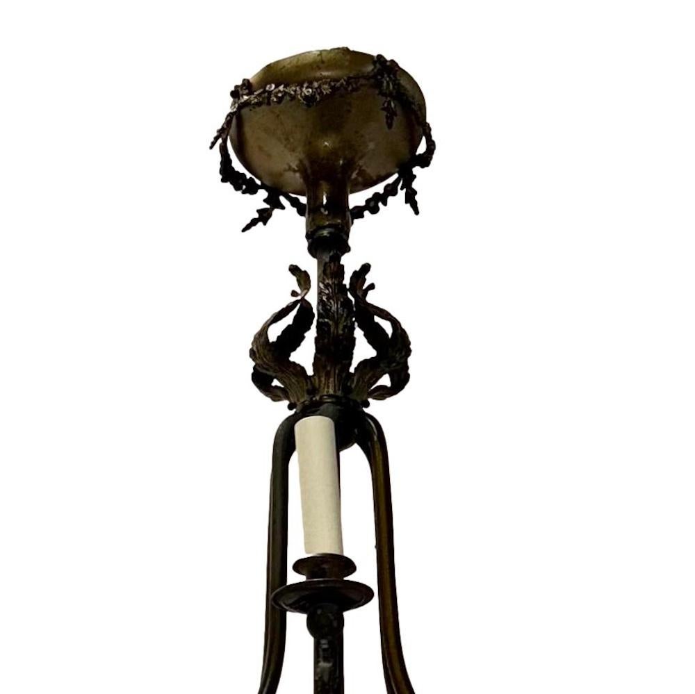 A circa 1900 English bronze chandelier with 6 arms and 2 interior lights. Body with red glass insets.

Measurements:
Drop without the fabric: 31″
Drop with the fabric: 39″
Diameter: 32″
