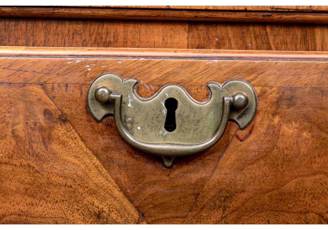 Une commode anglaise particulièrement belle et colorée avec un intéressant placage en coupe d'angle sur les deux tiroirs supérieurs et tous les tiroirs avec de subtiles bandes. Les tiroirs à queue d'aronde fonctionnent tous librement et les poignées