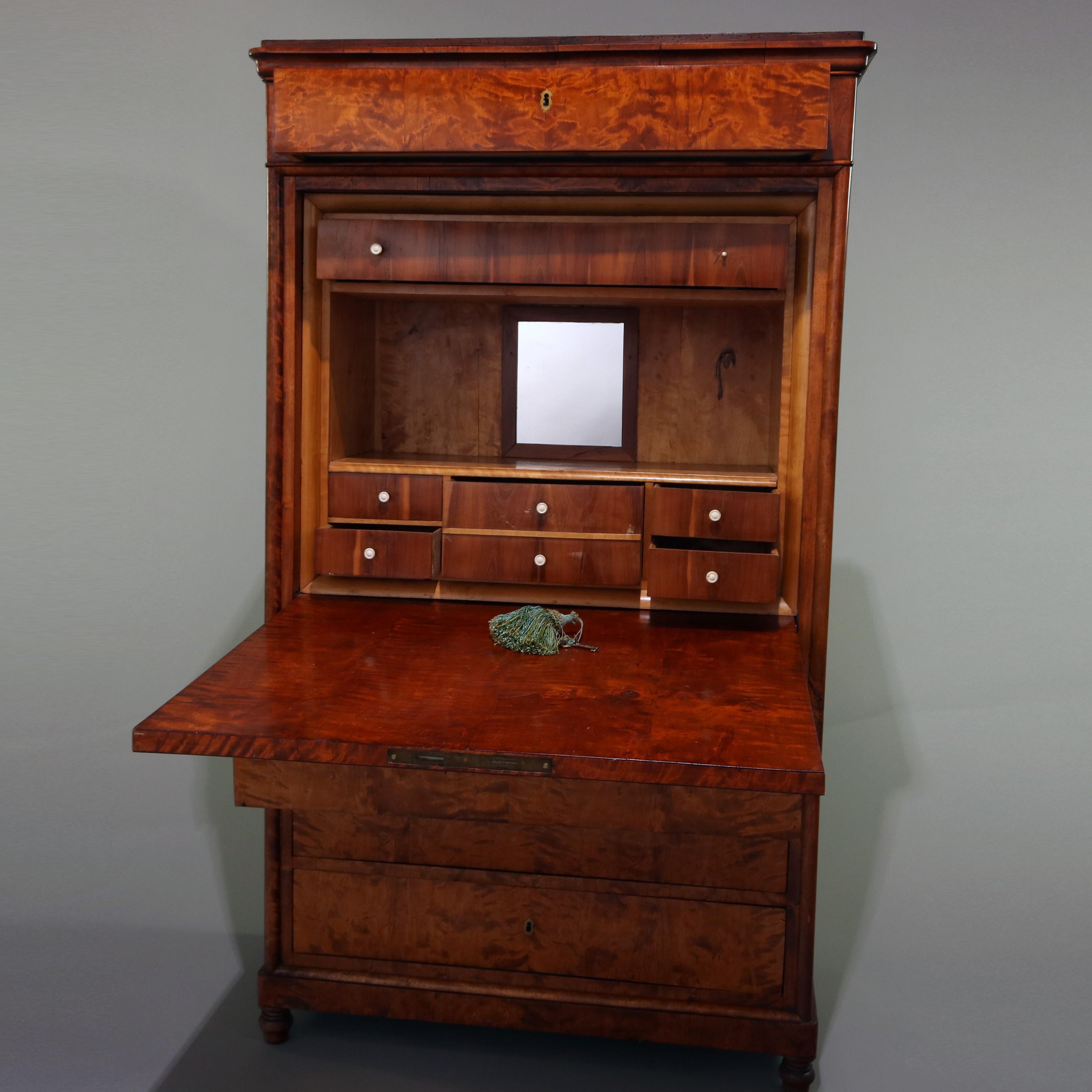 An antique English Biedermeier Abattant secretary features burl wood construction with frieze drawer surmounting drop front secretary opening to reveal writing surface and interior storage compartments and drawers over three lower long drawers and
