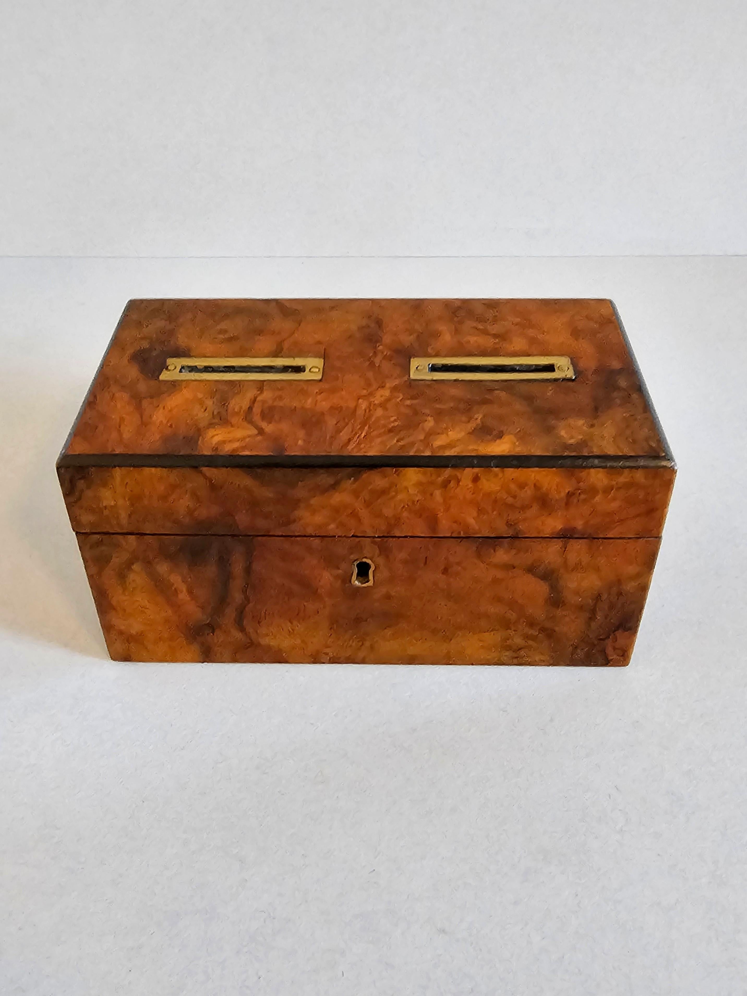 A stunning and scarce antique English Victorian era burlwood voting box.

Hand-crafted in the 19th century, the small table box having a rectangular case with hinged lid top fitted with two brass slots, the exterior finished in warm rich highly