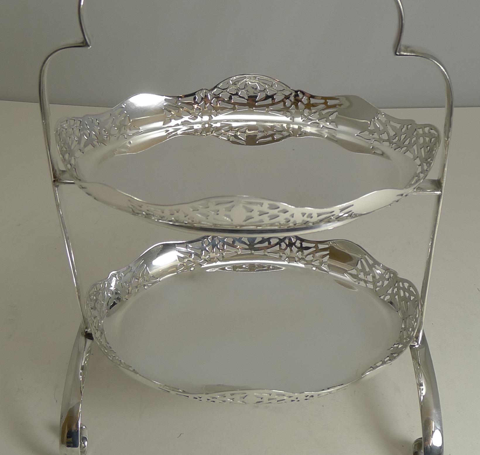 A lovely petite two-tier cake stand, perfect for serving a multitude of treats from cup cakes to hors d'oeuvres to chocolates to cocktail snacks.

Made from English silver plate, the frame is fully marked by the silversmith, Thomas White of