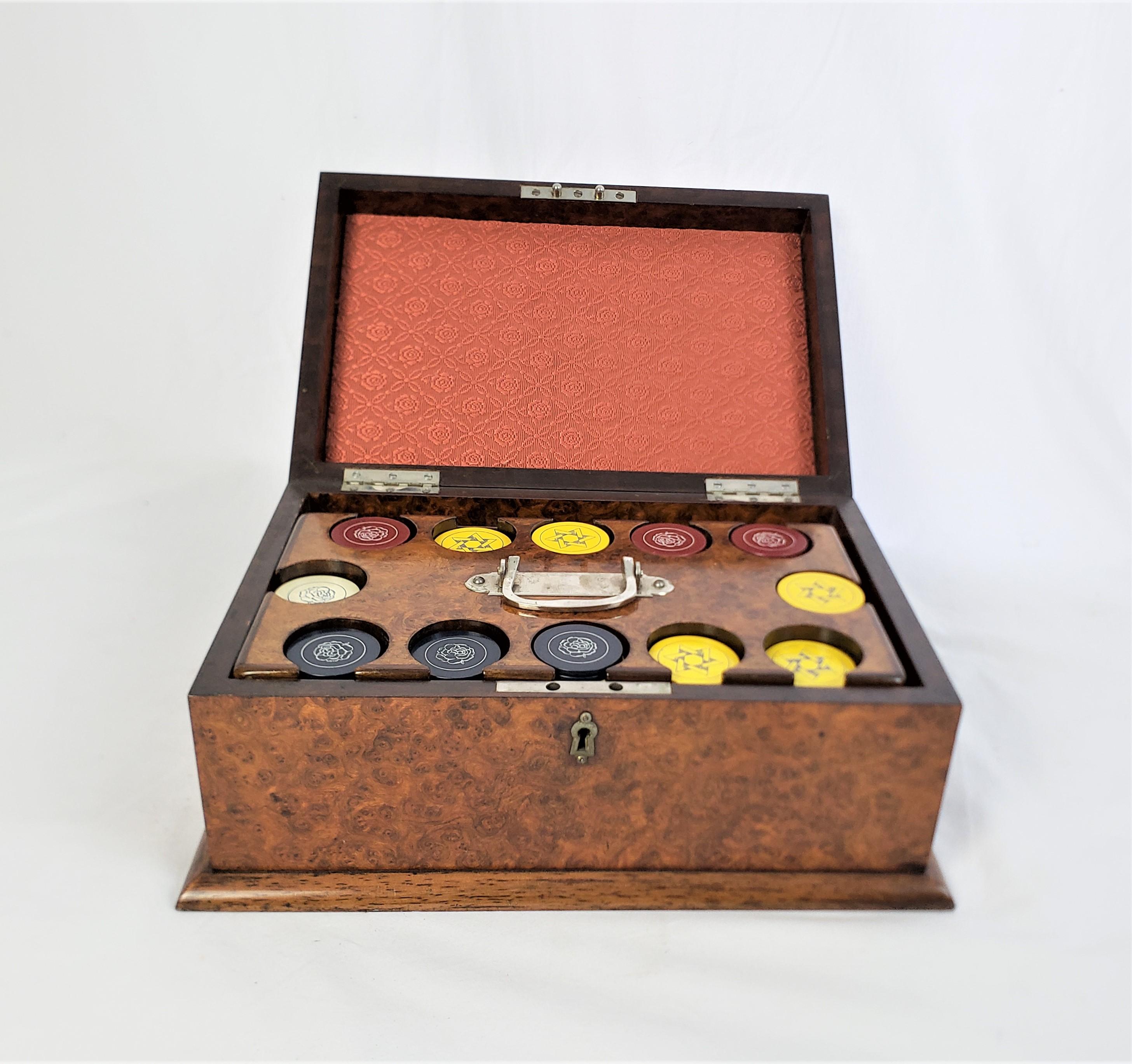 This antique card and poker chip box is unsigned, but presumed to have originated from England and date to approximately 1900 and done in the period Edwardian style. The box is composed of walnut and features a fitted walnut pull out carousel for