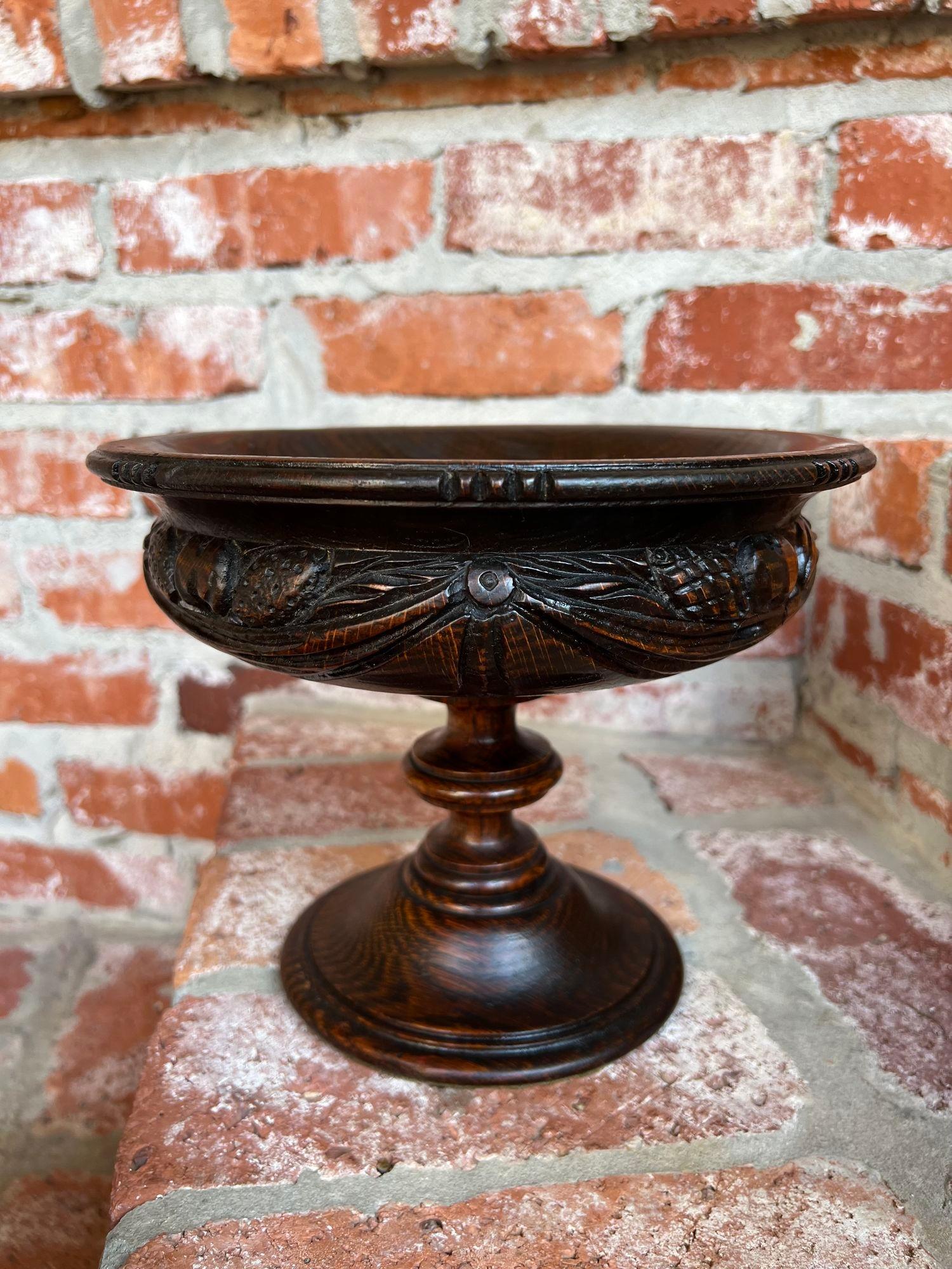 Antique English Carved Dark Oak Compote Pedestal Bowl Floral Dessert Stand.

Direct from England, a beautiful antique English oak compote. The deep, shaped bowl has beautiful hand carvings on the outer bowl, that include a variety of fruits, nuts,