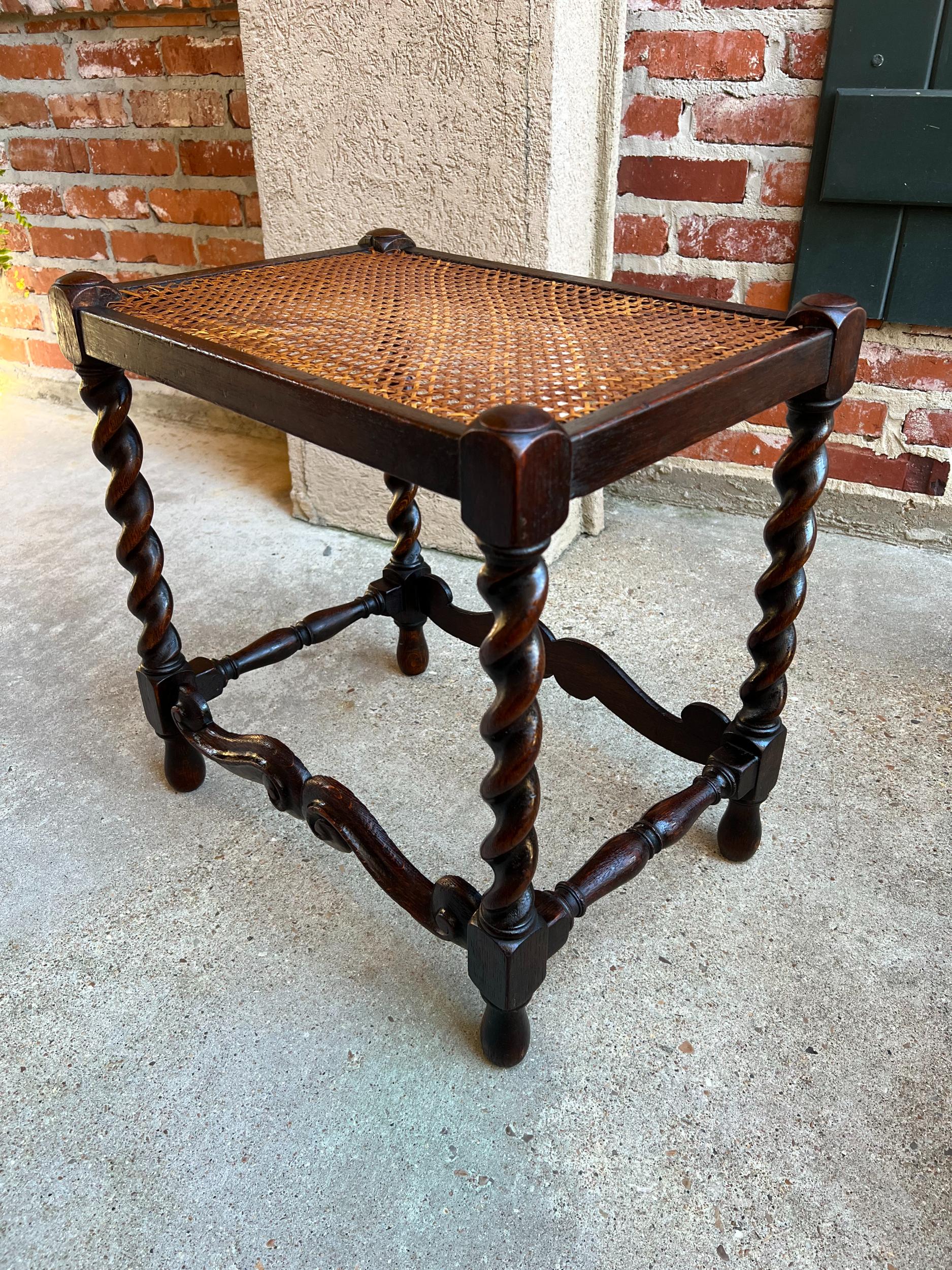 Antique English carved Oak Barley Twist bench stool Jacobean w Cane Top.

Direct from England, a wonderful antique English oak stool or bench.
Hand turned barley twist legs are joined by serpentine carved stretchers to the front and back, with