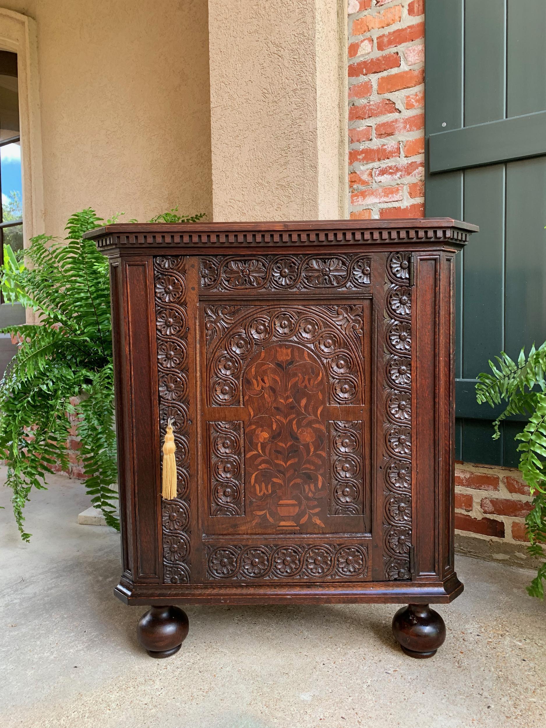 Antique English carved oak corner cabinet marquetry side table 19th century.

Direct from England, a highly carved antique oak corner cabinet or table.
Dentil trim crown below the beveled edge top, across the entire front and canted corners.
Wide