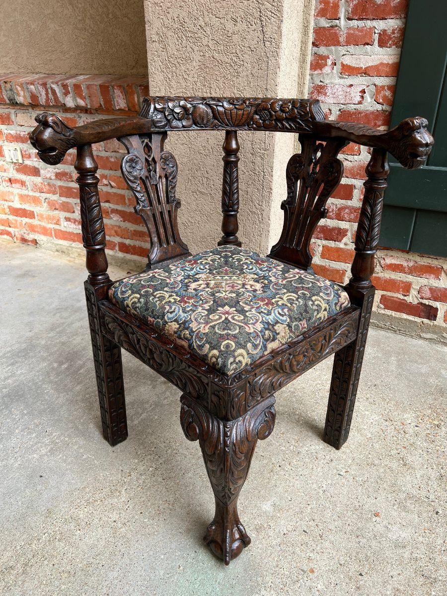 Direct from England, a gorgeous 19th century carved oak corner chair.
Thick, hand carved foliate back rail, with turned and carved lyre shaped supports, ending in dimensional mask handholds.
Fully carved straight legs to the sides, with a wide