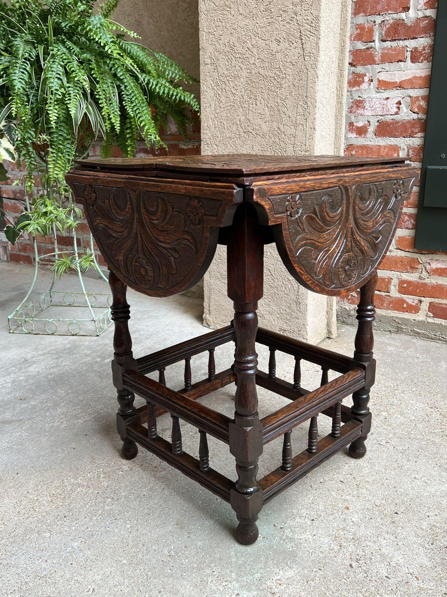 Antique English carved oak side hall table petite drop leaf tea wine table.
 
Direct from England, a heavily carved antique side table, in a versatile petite size. Four independent drop leaves, all scalloped edge with fully carved tops.
Turned
