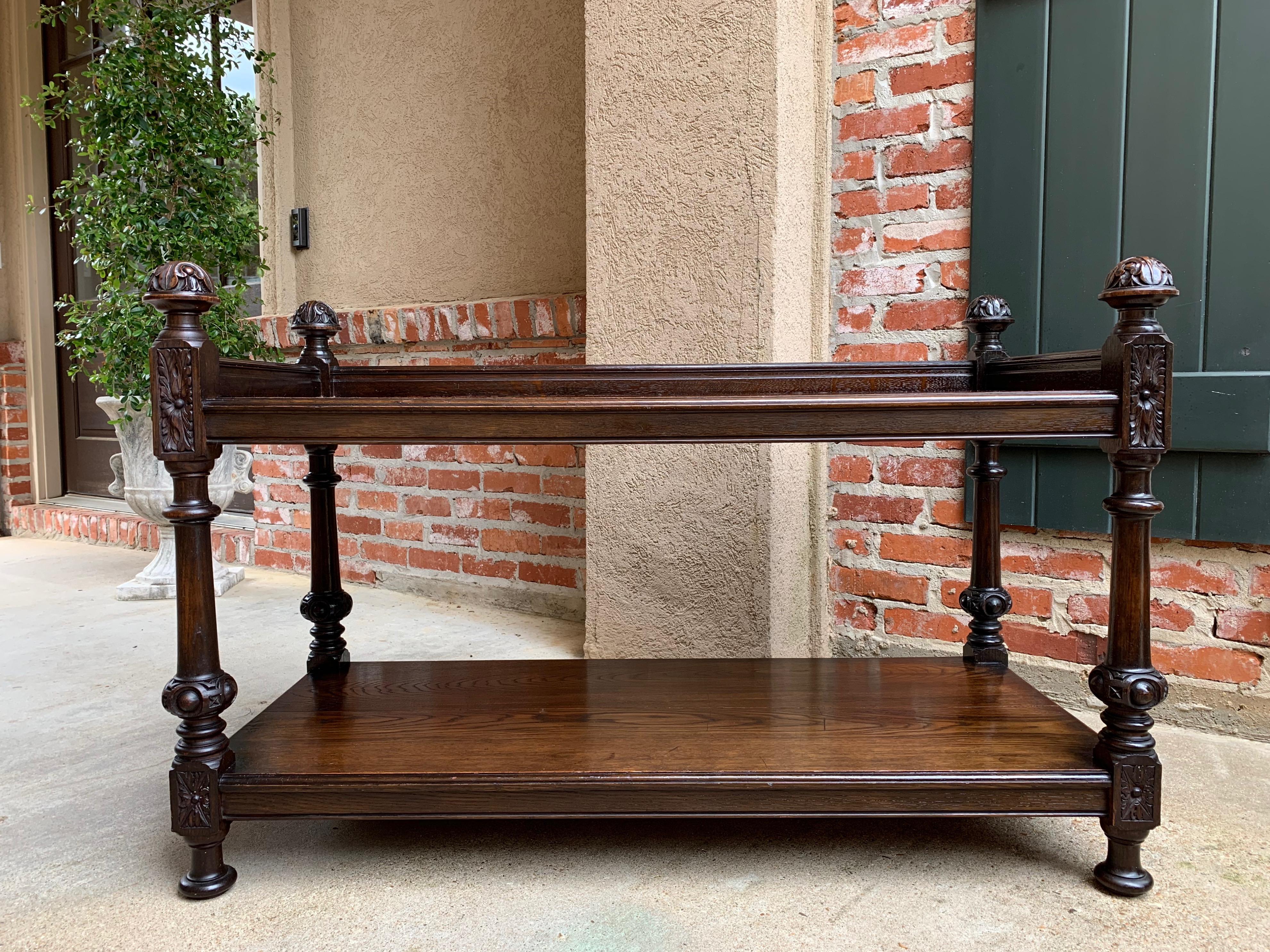 Direct from England, a stunning antique English oak two-tier table!
~ Gorgeous carvings on the large ball finials and large carved blocks
~ Baluster legs with carved bulbous lower accent over the lower cared blocks and bobbin feet
~ Upper shelf