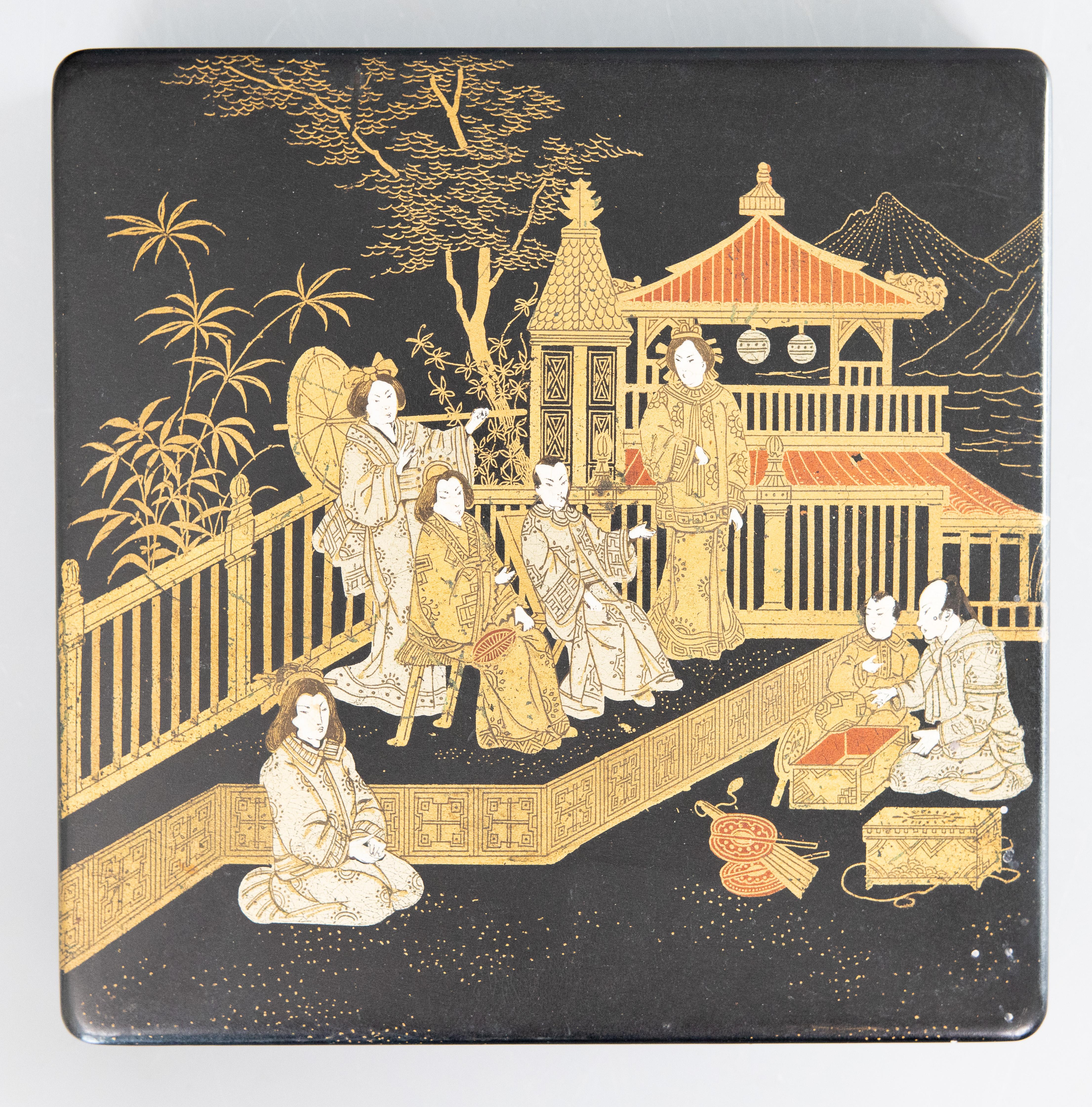 A superb antique English black ebonized japanned papier mache lidded box with an Asian chinoiserie design, circa 1880. This fine box is hand made with hand painted figures, a Chinese garden, and pagoda on a black lacquered background with gilt