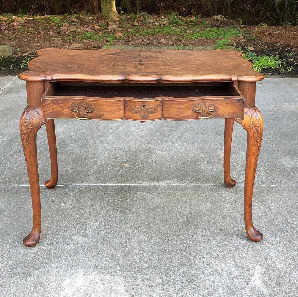 Antique English Chippendale desk, writing table features the timeless style produced with a contoured and beveled edge, a full width drawer with brass appointments, and carved shoulders on the cabriole legs terminating in club feet,
circa early