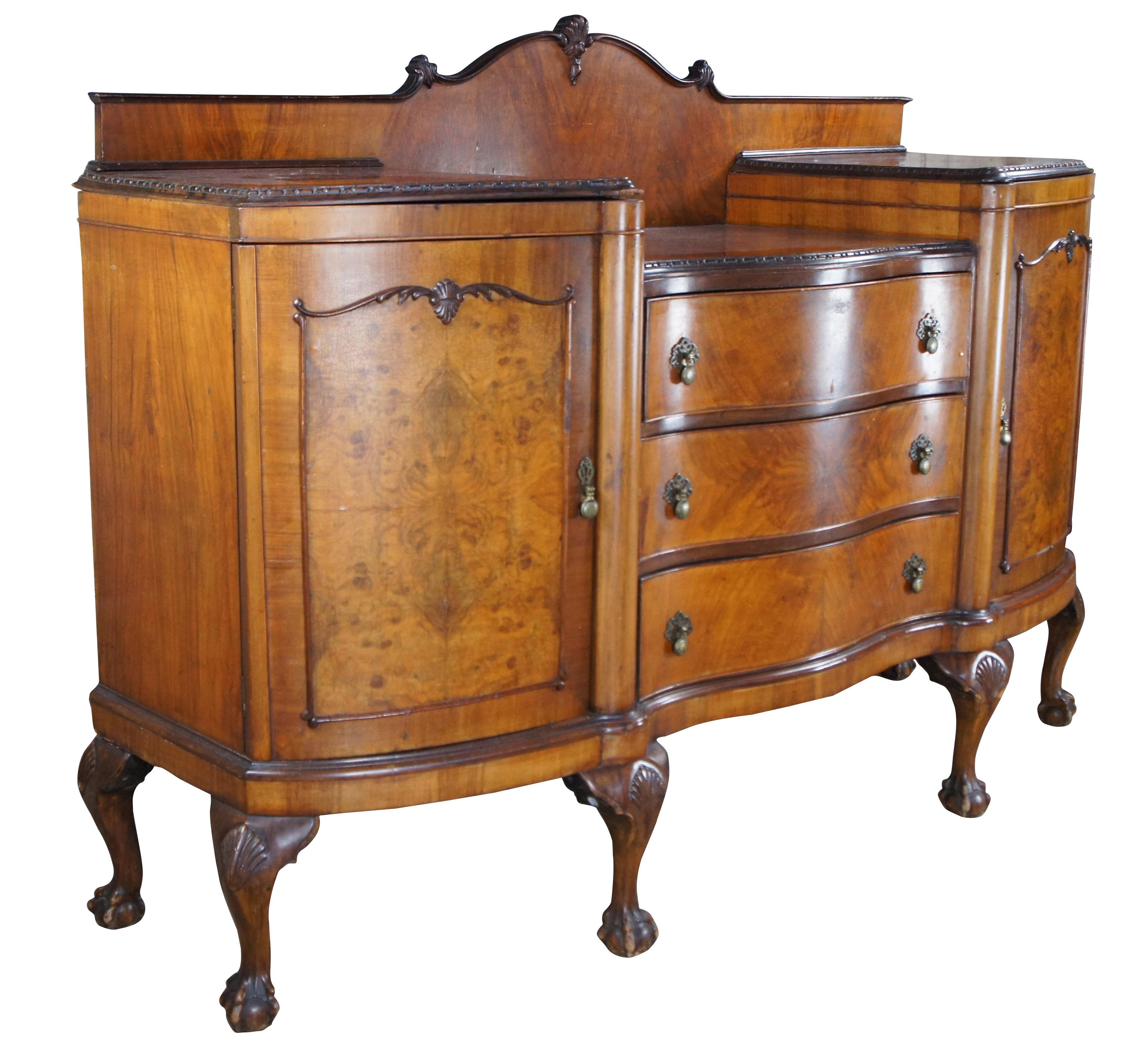 Sunning Antique English Chippendale style sideboard, circa 1870s.  Features a serpentine form made from walnut with matchbook burl and crossbanding.  The buffet showcases a camelback-shaped backsplash in front of a dropwell with three