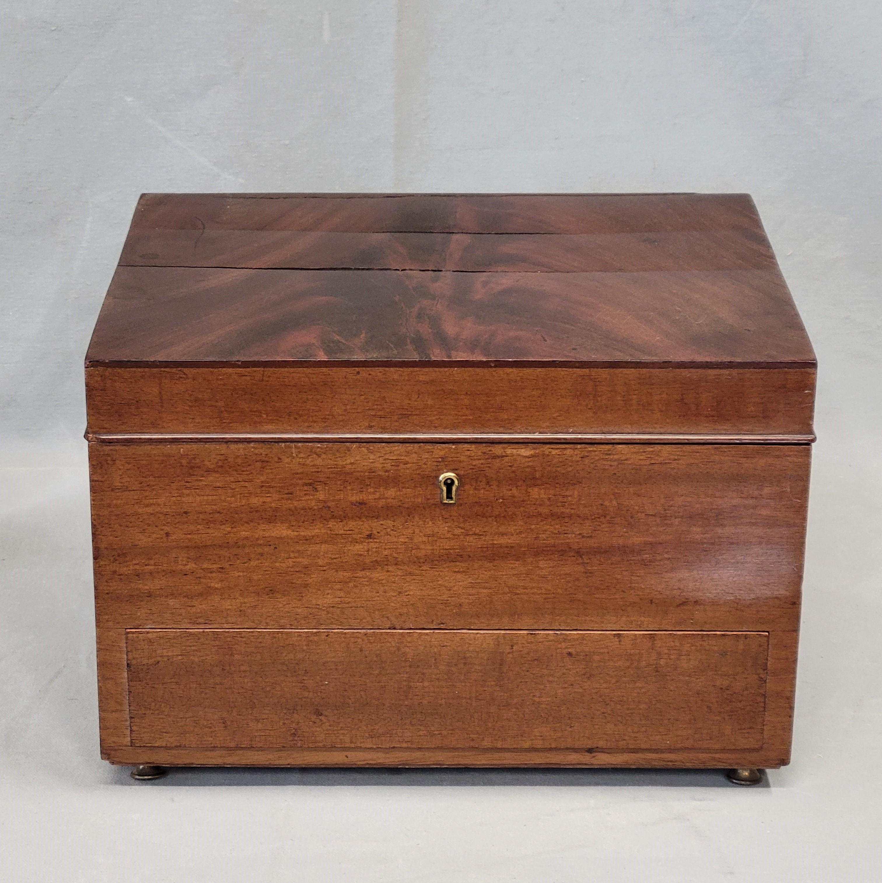 An elegant and functional antique circa 1900 English flame mahogany jewelry box by esteemed furniture maker Maple & Co. The interior is fitted with spring green velvet and ample storage space. Maker plaques are printed 