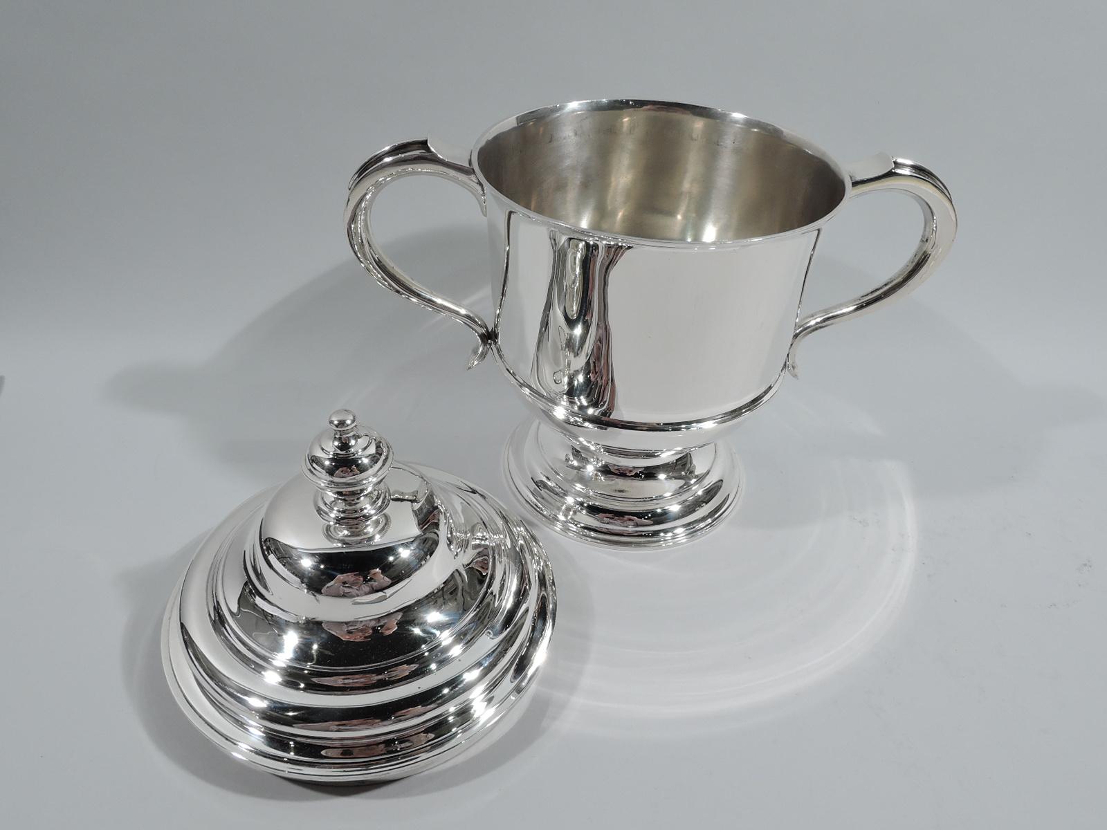 George V sterling silver covered urn. Made by Lionel Alfred Crichton in London in 1927. Girdled bowl on stepped and domed foot; capped s-scroll side handles. Cover double-domed with vasiform finial. Traditional Classical form with lots of room for