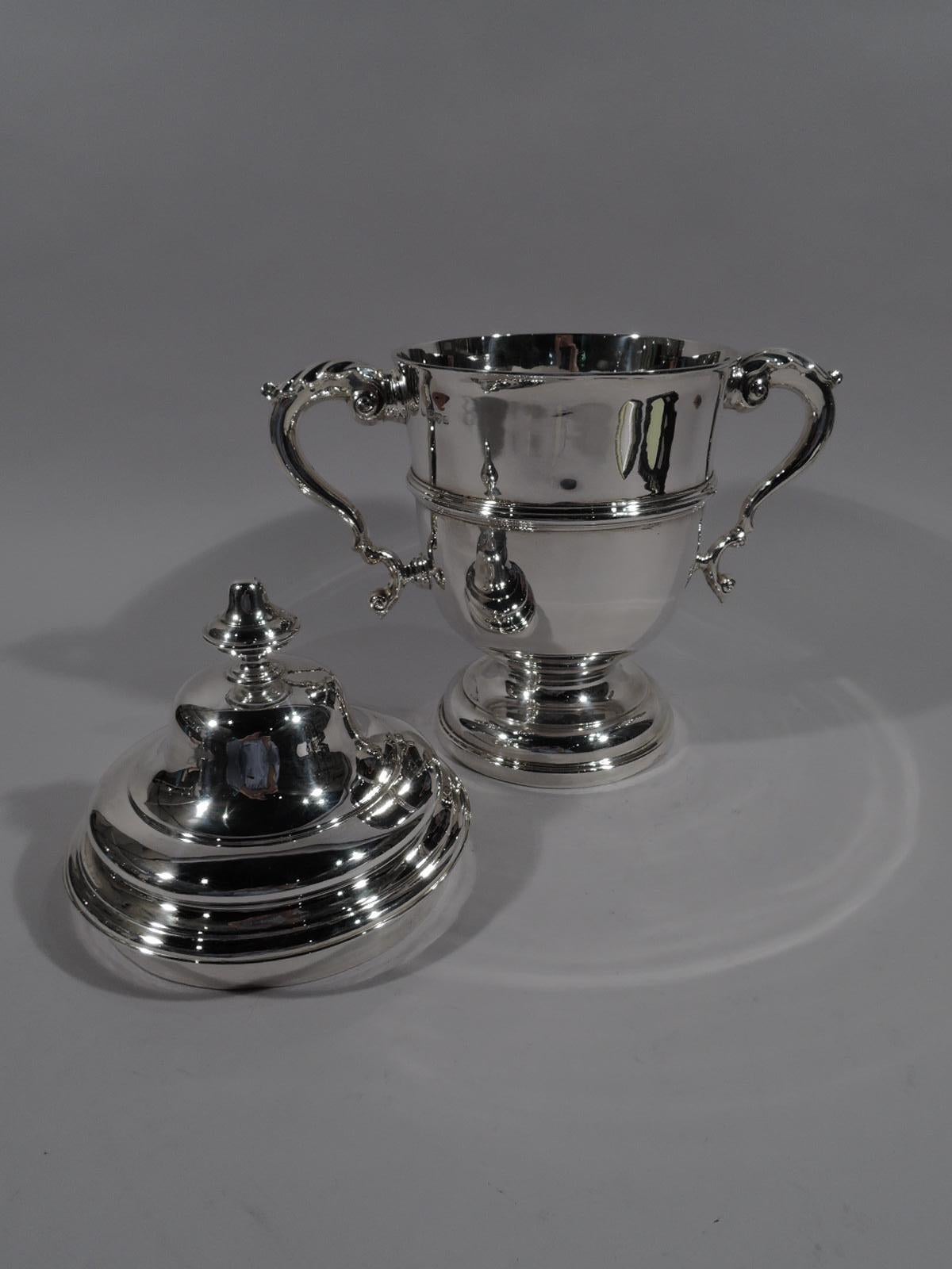 Edwardian Classical sterling silver covered trophy cup. Made by George Nathan & Ridley Hayes in Chester in 1905. Girdled urn with leaf-capped double-scroll handles and stepped and domed foot. Cover double domed with vase finial. Fully marked.